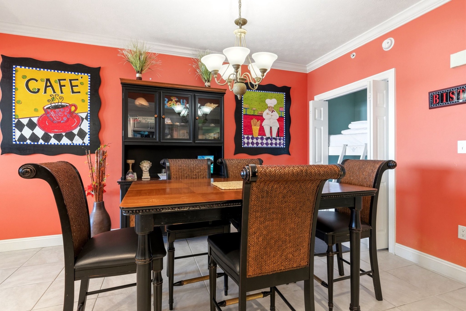 Gather around this vibrant dining space where coral walls and cafe-themed art create a warm atmosphere for your memorable meals together.
