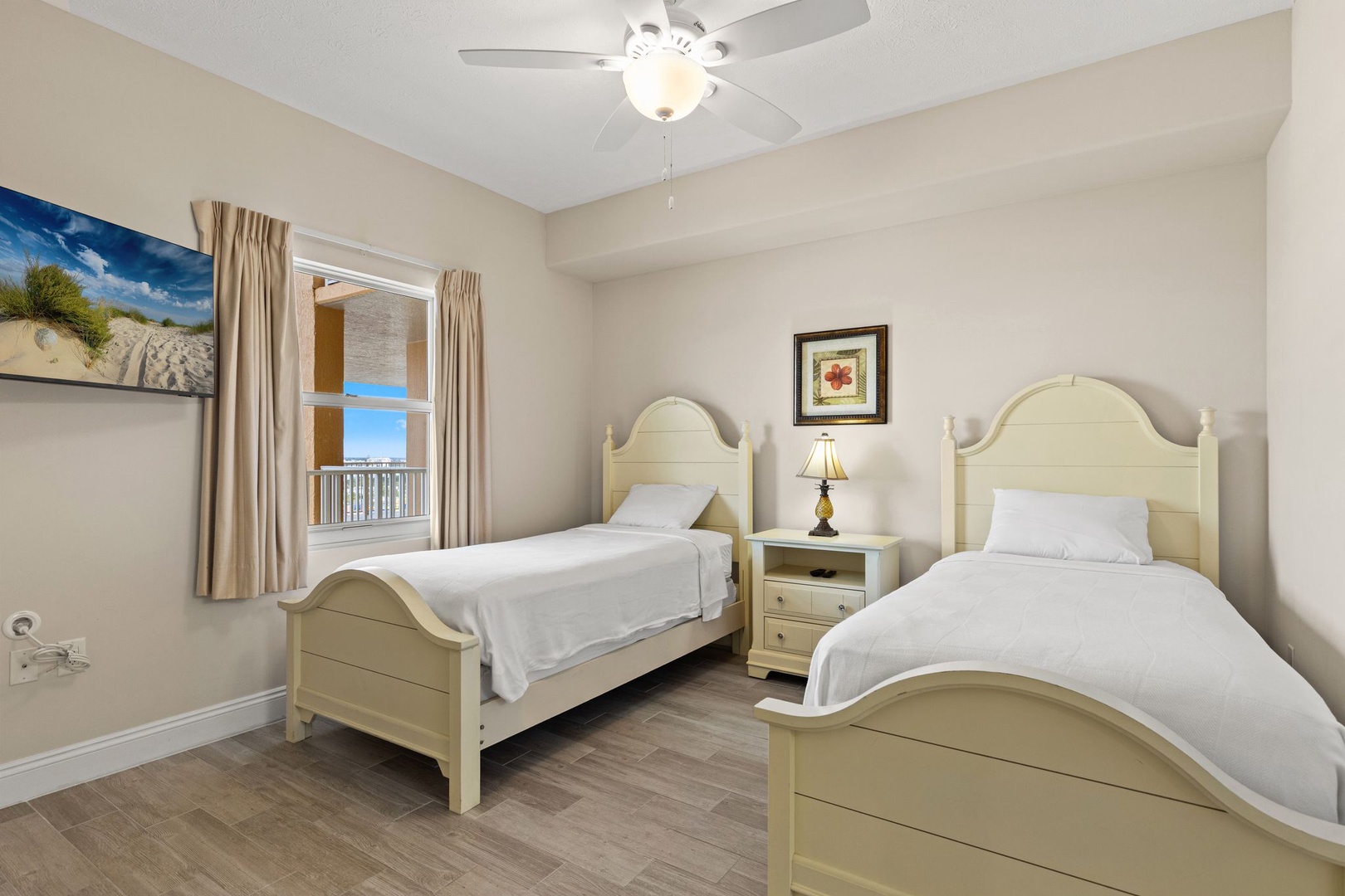 Rest peacefully in twin beds with crisp linens, gentle ceiling fan breeze, and coastal artwork creating your serene seaside retreat.