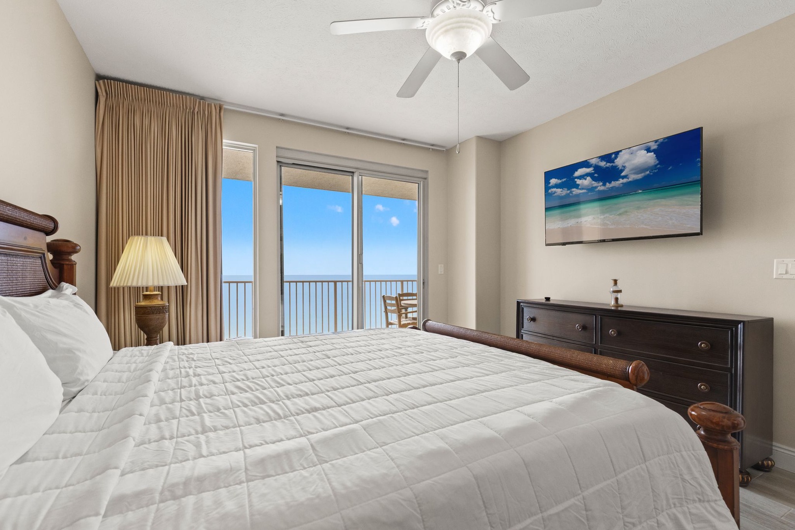 Wake up to endless ocean views from your private balcony in this serene master bedroom with coastal comfort.