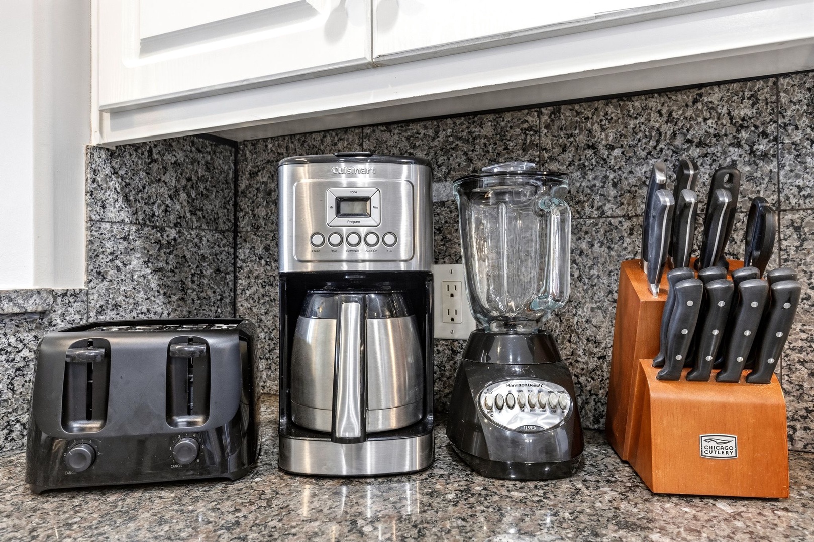 Your fully equipped kitchen counter features everything you need: coffee maker, blender, toaster, and quality knives for easy meal prep.