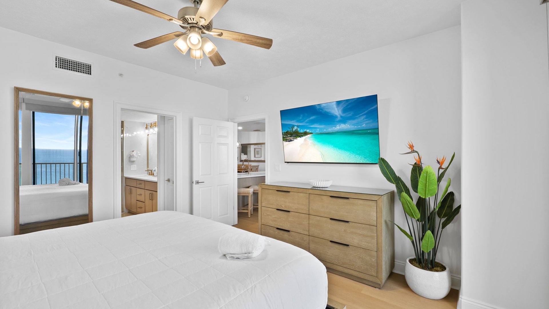 Drift off to sleep in your serene bedroom with ocean breezes from the ceiling fan and tropical vibes from the wall-mounted TV.