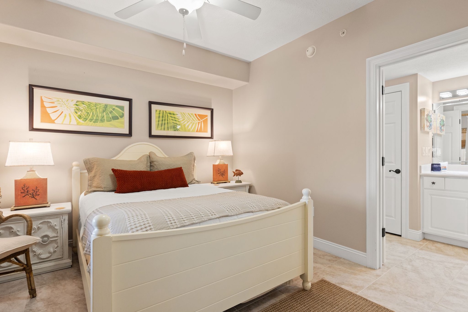 Step into your peaceful bedroom retreat, where neutral tones and tropical artwork create a calming oasis. The ceiling fan keeps you cool while you sink into plush bedding after a day of adventure.