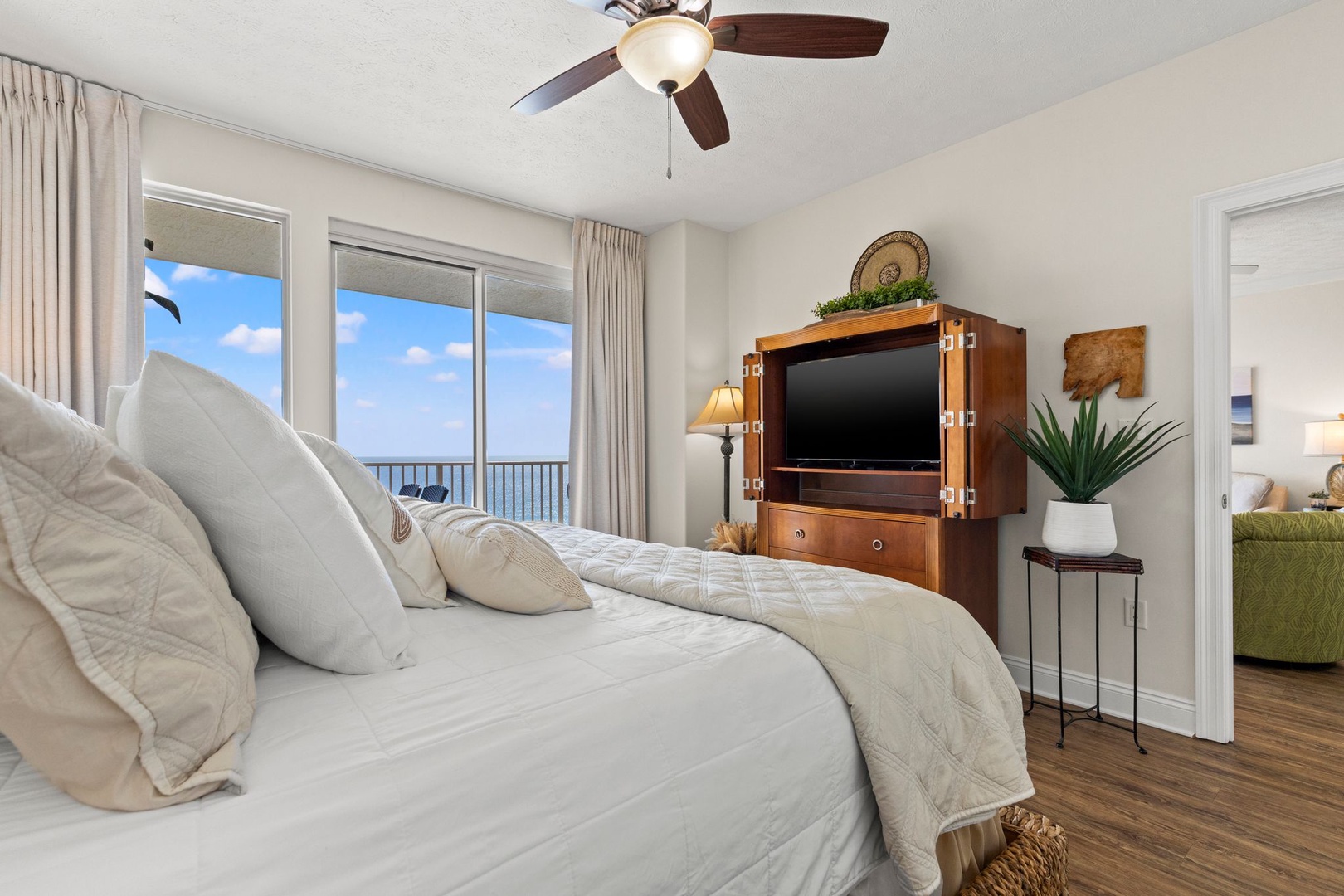 Drift off to the sound of waves in this serene coastal bedroom. You'll love waking up to stunning ocean views through the balcony doors, and relaxing under the ceiling fan after a day in the sun.