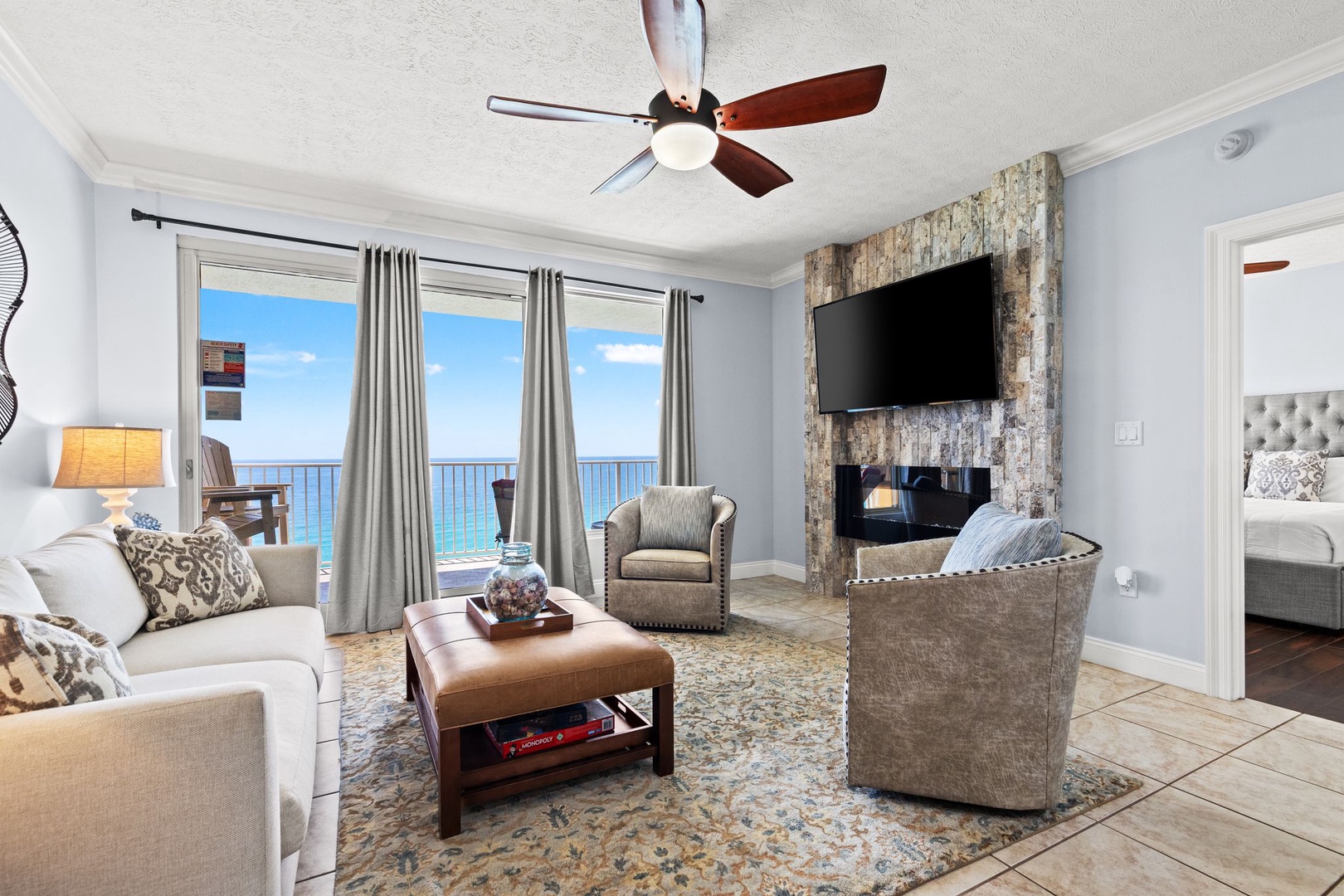 Unwind in your coastal living room, where plush seating, a cozy fireplace, and sweeping ocean views through the balcony doors create the perfect retreat.