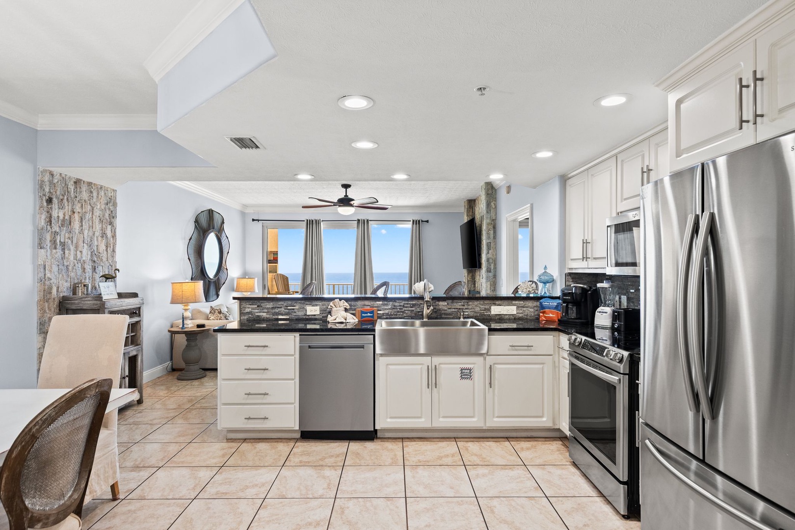 Your modern kitchen invites you to cook with ocean views streaming through the windows. Crisp white cabinetry, granite counters, and stainless appliances make meal prep effortless while the sea breeze beckons.