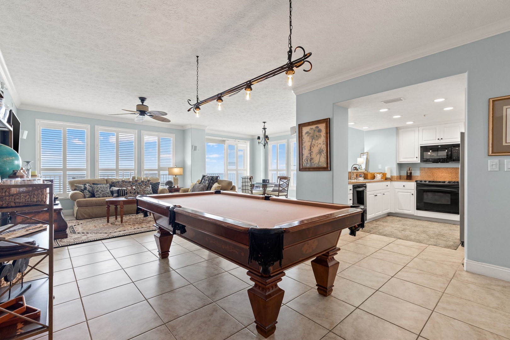 Challenge a friend to a game of pool in this open-concept space, where natural light floods through expansive windows and your kitchen is just steps away for easy entertaining.