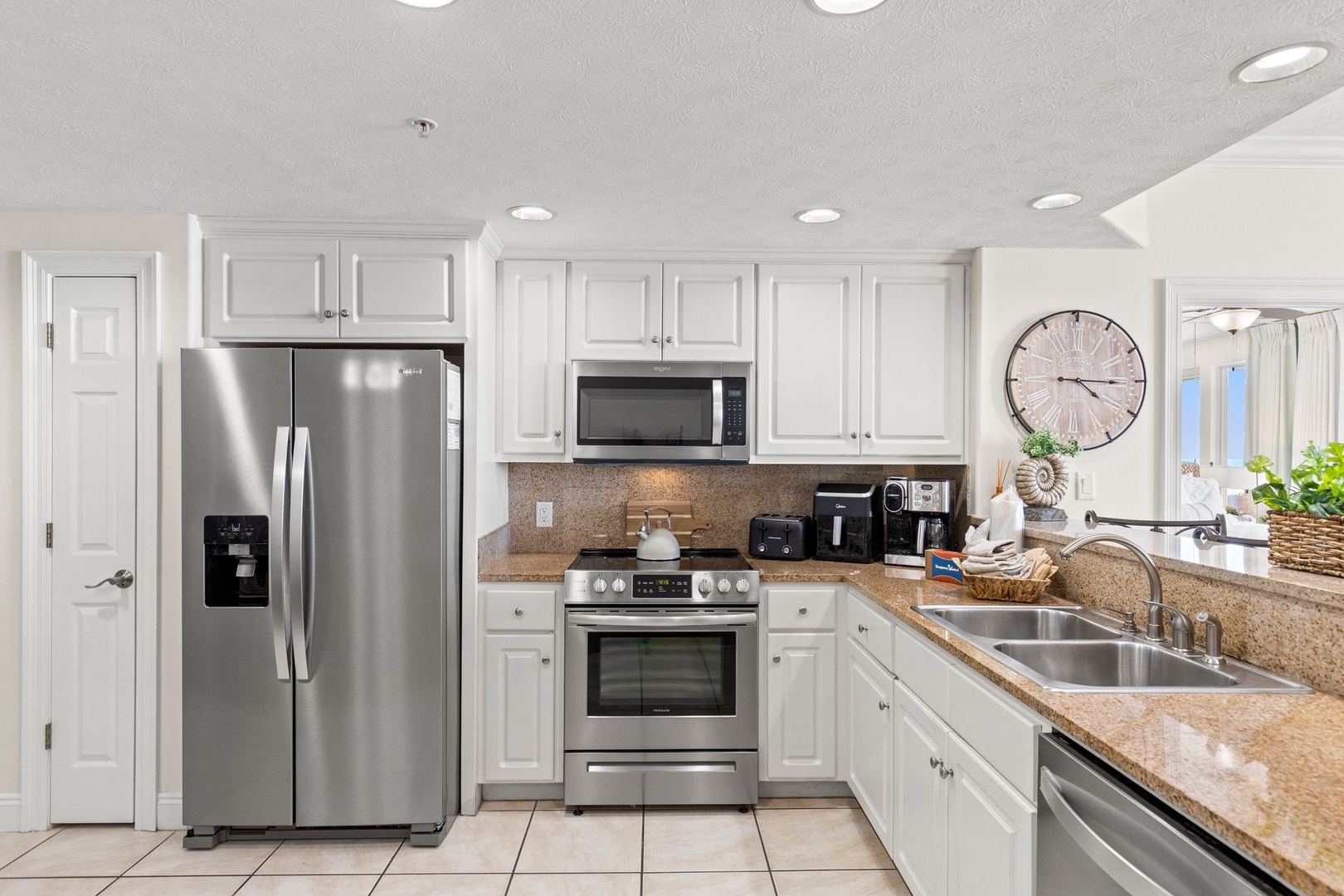 Your fully-equipped kitchen awaits with modern stainless appliances, bright white cabinetry, and plenty of counter space for preparing meals during your stay.