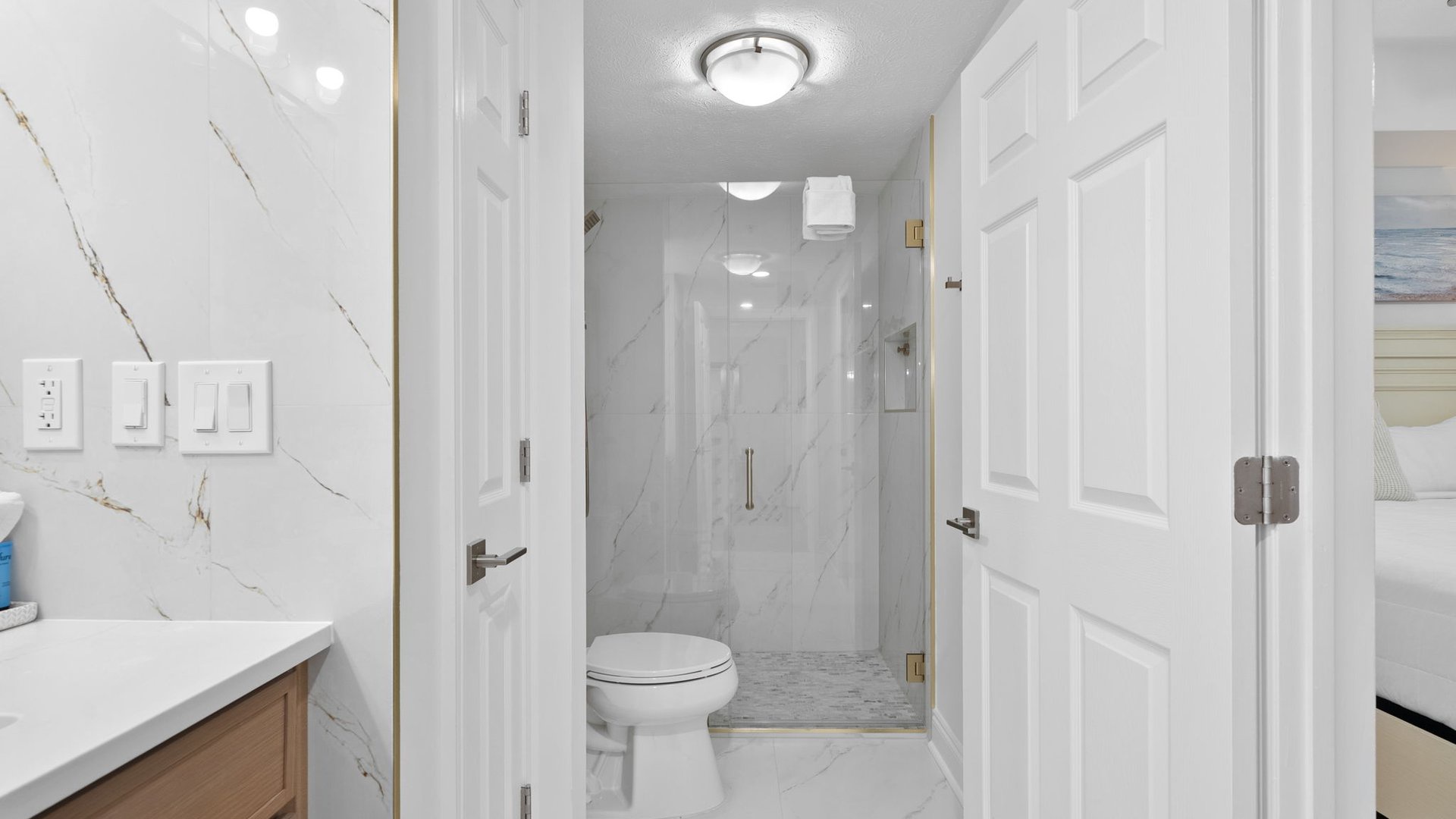 Step into your elegant marble bathroom with luxurious walk-in shower and pristine finishes that make every morning feel like a spa retreat.