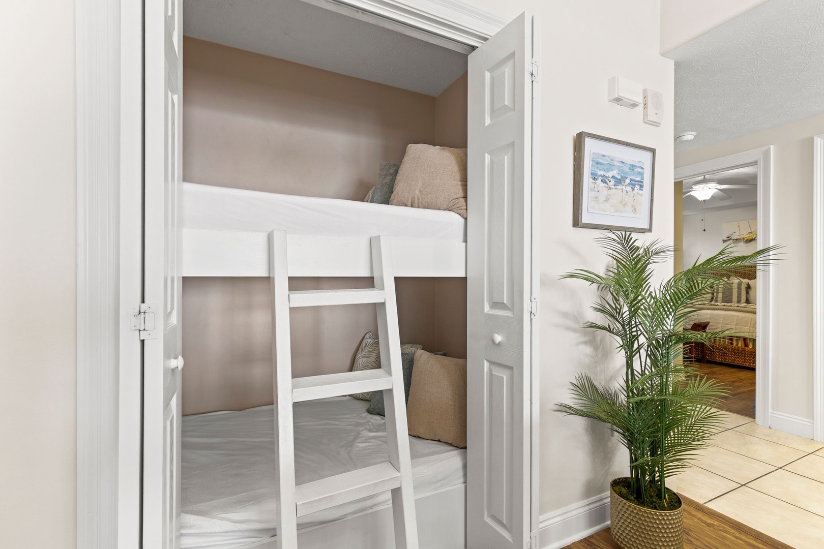 Your bunk room awaits, perfect for kids or friends to share a cozy space after sun-soaked beach days. Coastal art and warm tones create a relaxed, homey vibe.