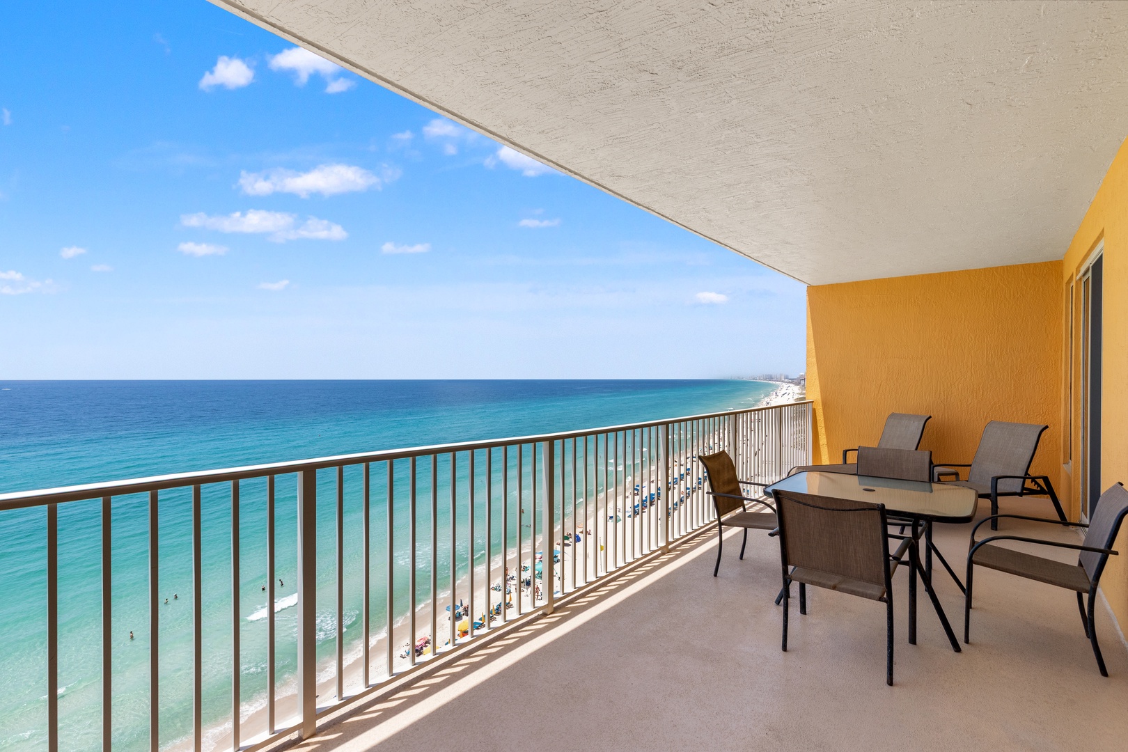 Spacious private balcony where you can savor morning coffee while watching gentle waves roll onto pristine white sand, with comfortable seating for six to enjoy spectacular turquoise water views and coastal breezes.