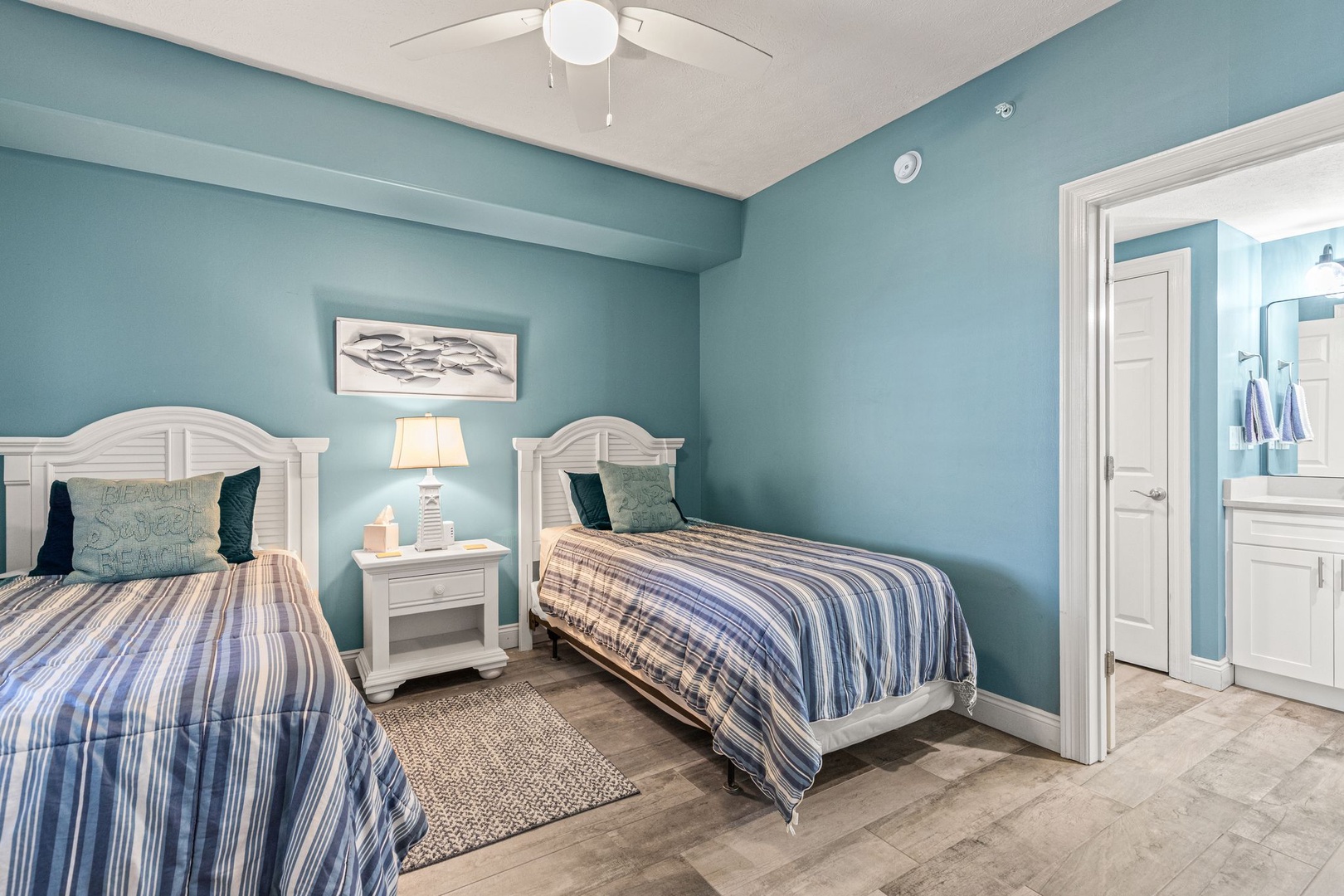 Sink into restful sleep in your coastal-inspired twin bedroom with crisp linens, soft bedside lighting, and a ceiling fan keeping you cool through the night.