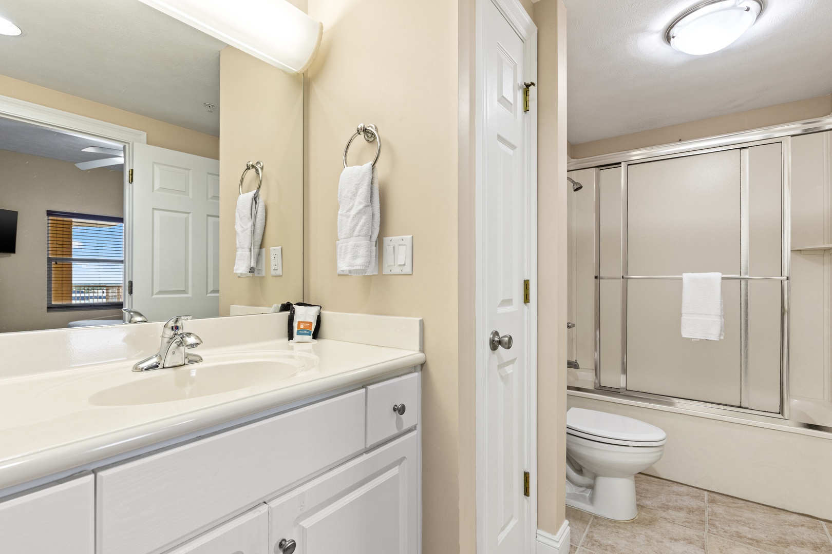 Step into your private en-suite bathroom, complete with dual vanities, fresh towels, and a spacious walk-in shower—perfect for unwinding after a day of exploring.