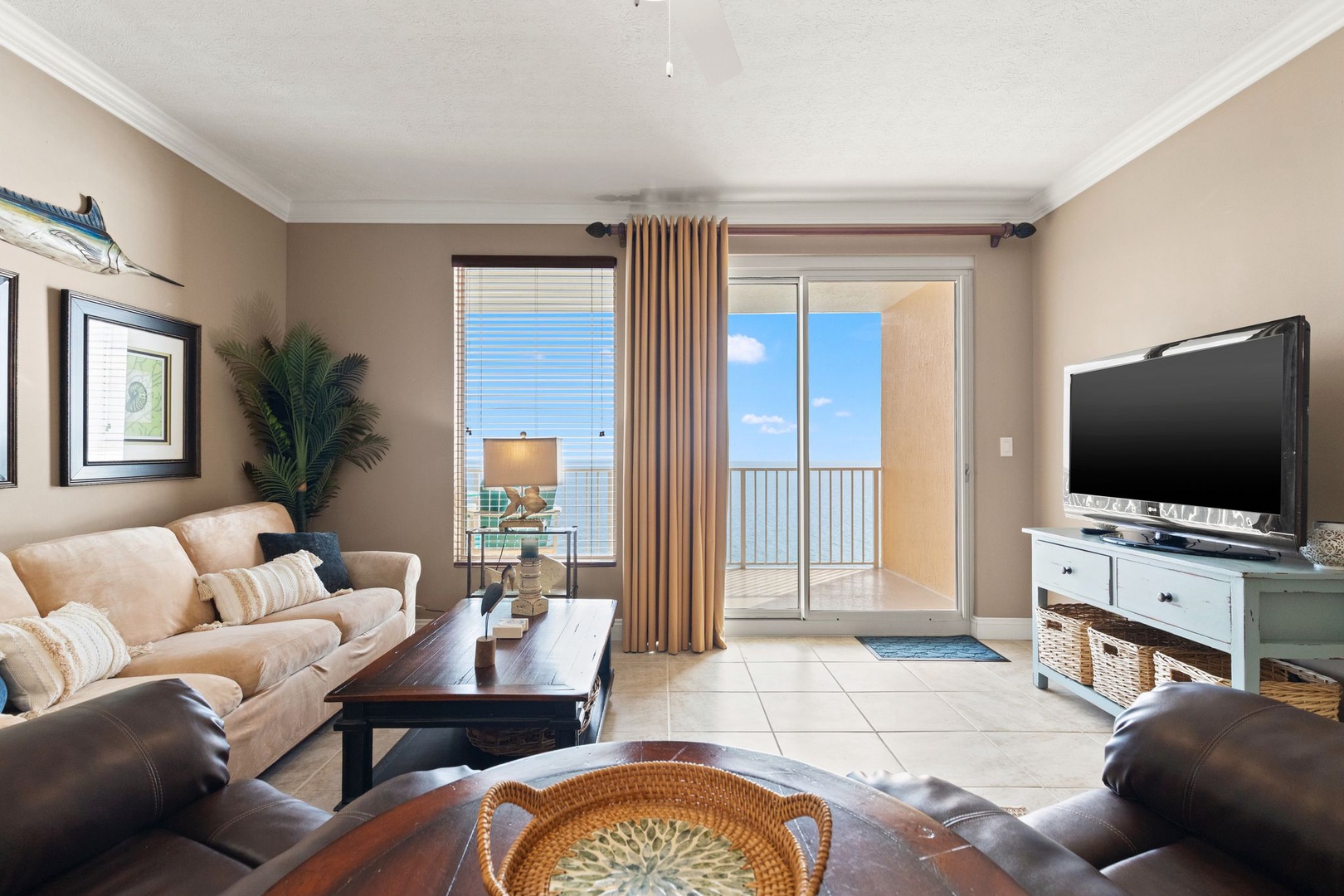 Settle into this inviting living room with plush seating, coastal décor, and sweeping sea views from your private balcony—perfect for relaxing after a day at the beach.