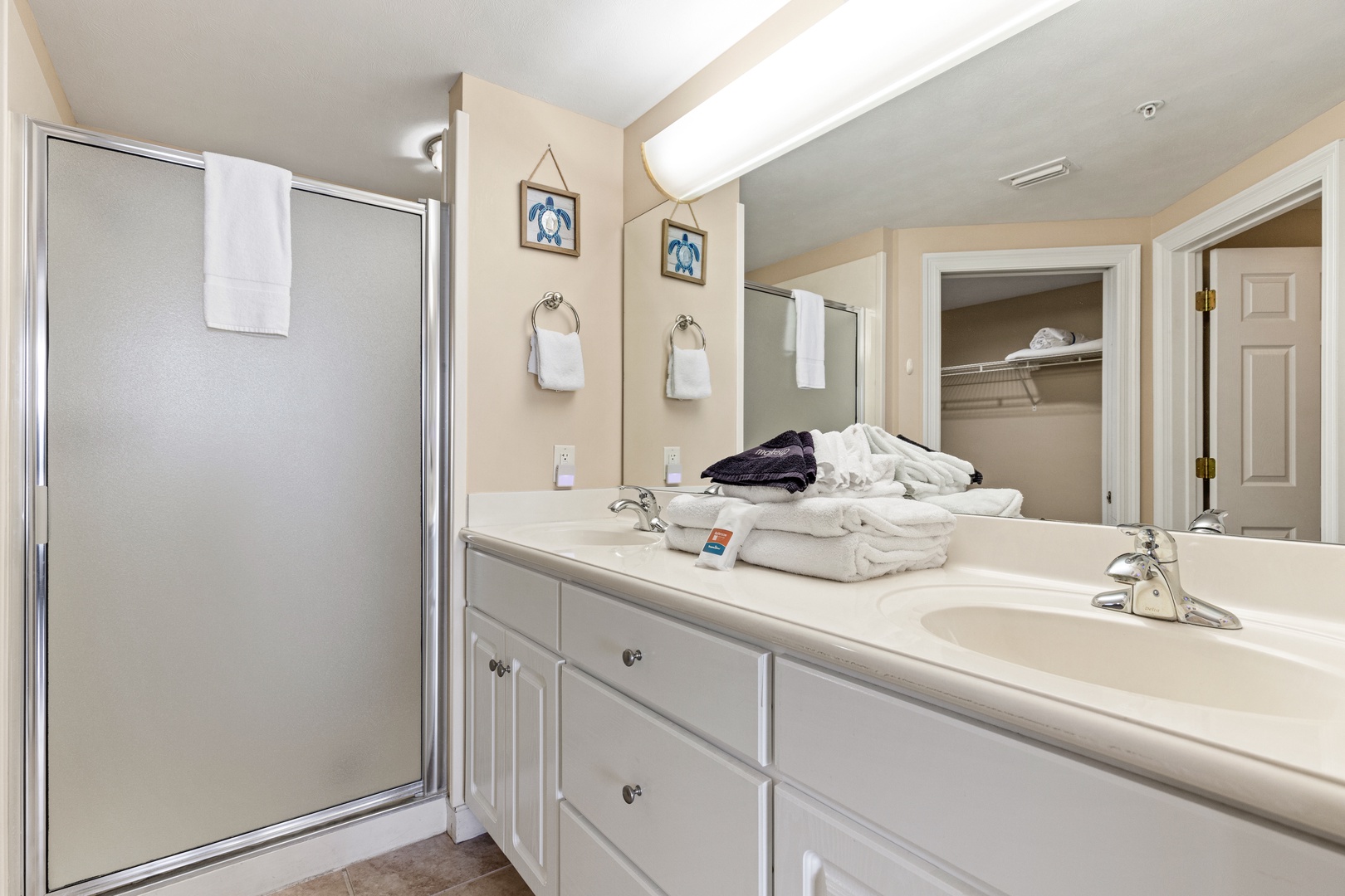Step into your spacious private bathroom with dual sinks, generous counter space, and fresh towels ready for you. The glass-enclosed shower and ample storage make it easy to settle in and feel at home.