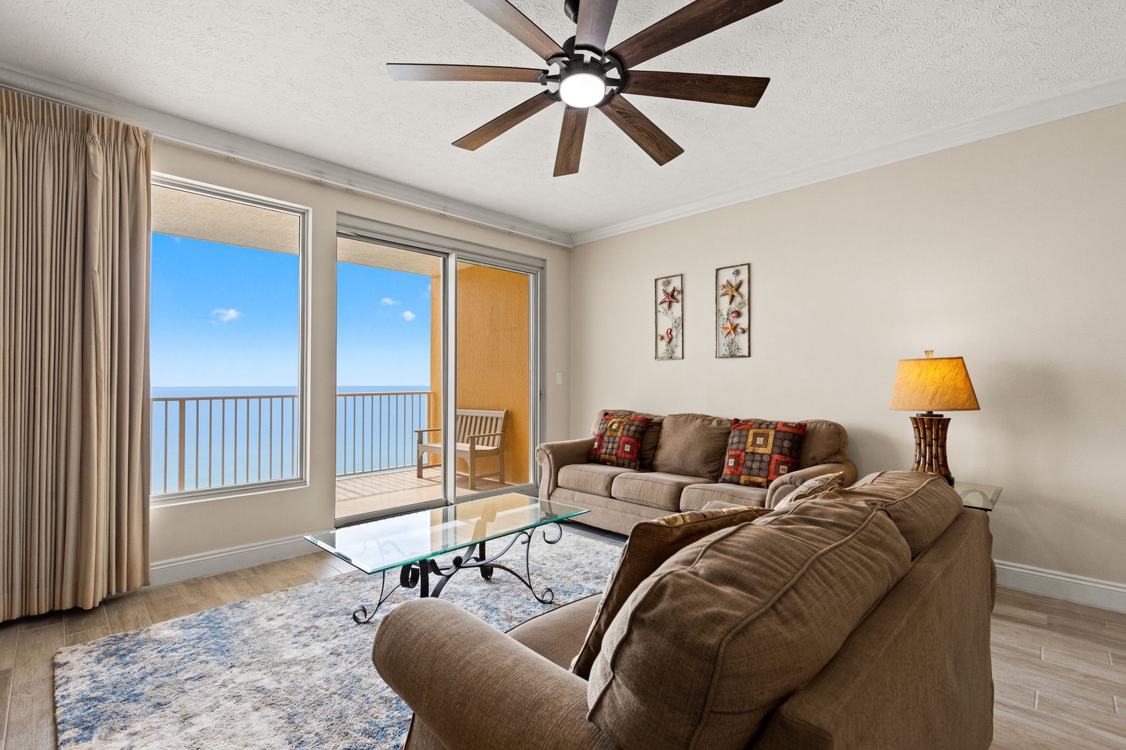Relax in your bright living room with stunning ocean views and gentle ceiling fan breeze.