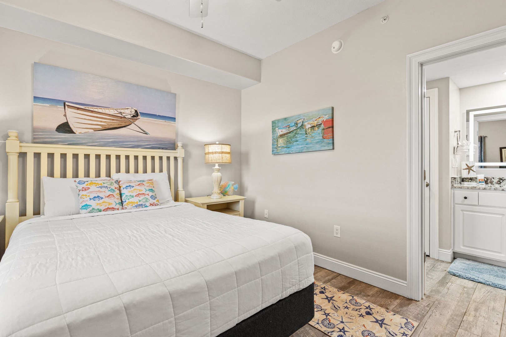 Sink into crisp linens and coastal charm. Your beachside bedroom features a plush bed, nautical artwork, and vaulted ceilings that create an airy retreat after sun-filled days.
