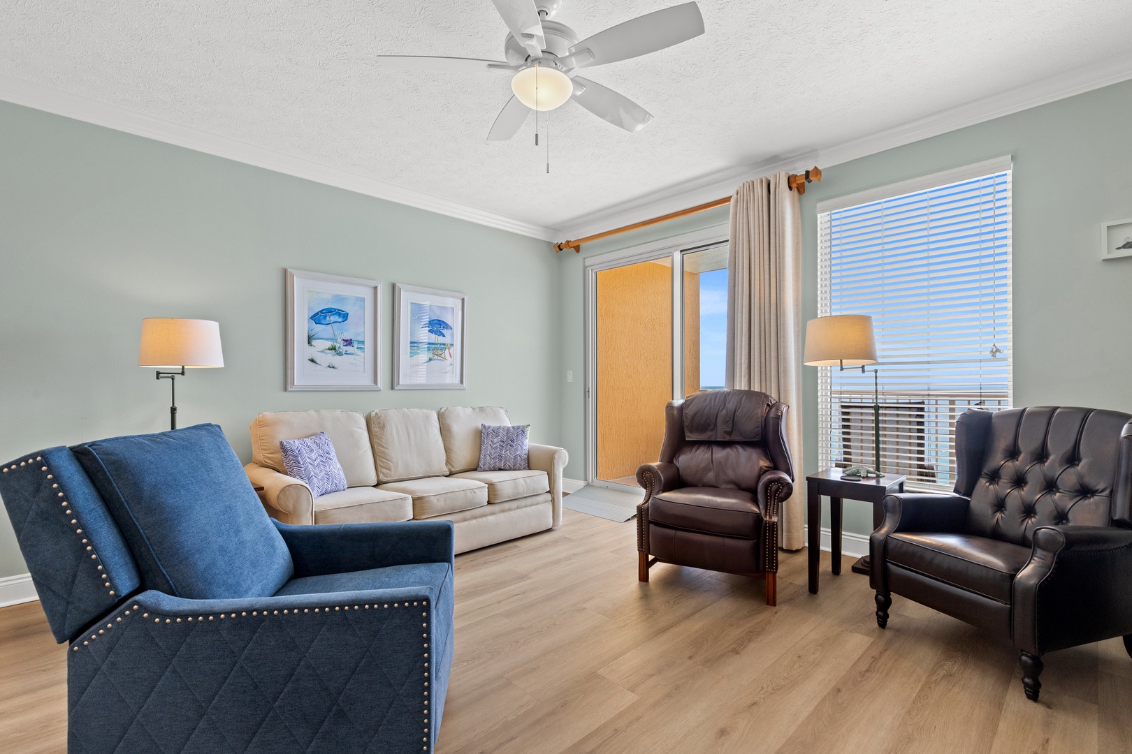 Relax in your beautifully appointed living room with comfortable seating, gentle ceiling fan, and peaceful coastal artwork creating the perfect atmosphere for unwinding.