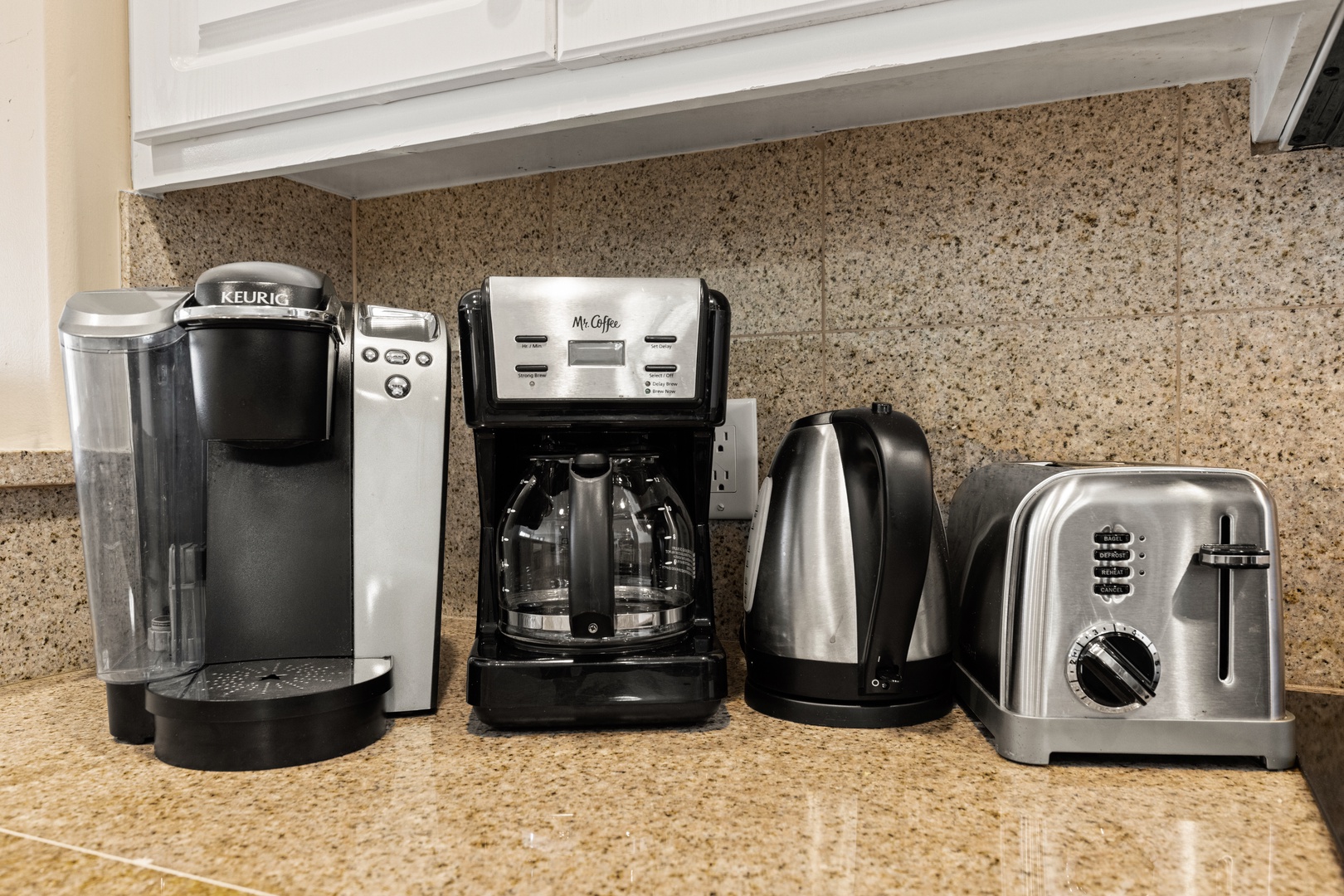 Your mornings start easy with a complete coffee bar: Keurig single-serve, drip coffee maker, electric kettle, and toaster ready on granite counters.