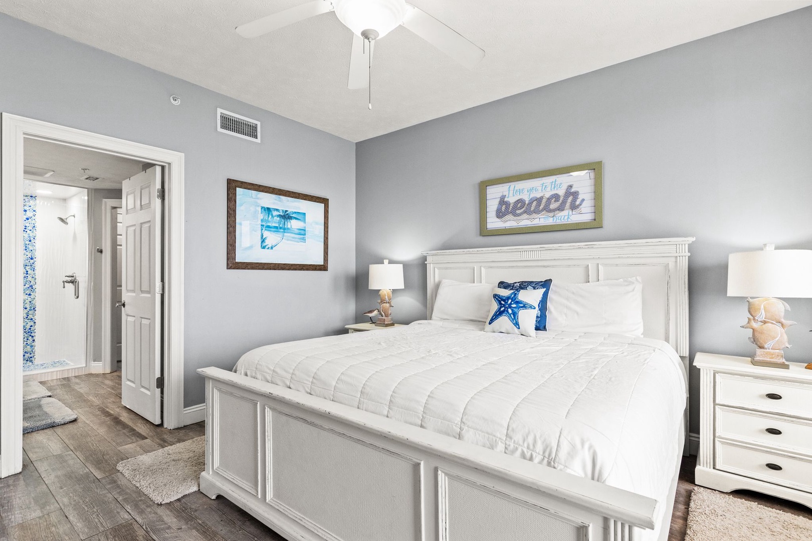 Your coastal-inspired bedroom features a plush queen bed, calming beach decor, and serene shades of blue and white—perfect for restful nights after long days in the sun.