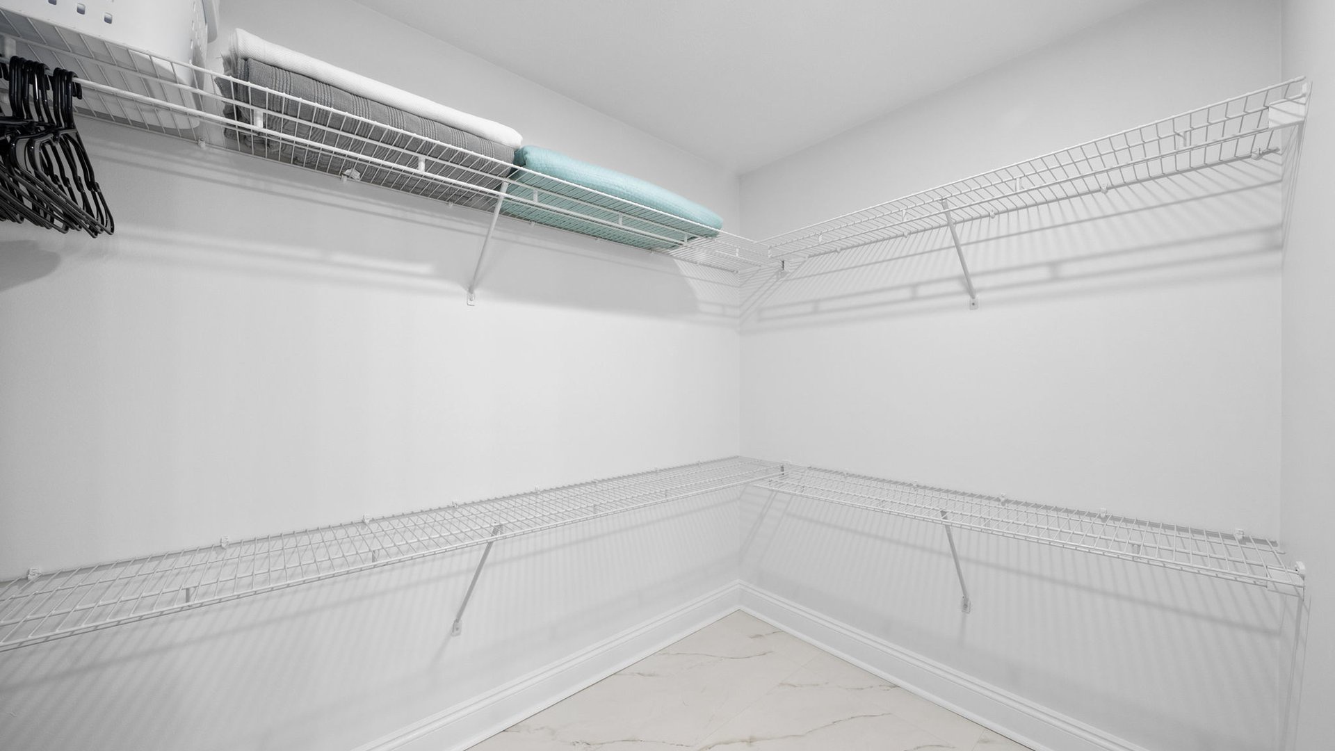 Your walk-in closet offers generous storage with wire shelving throughout, plus hangers ready for your wardrobe.