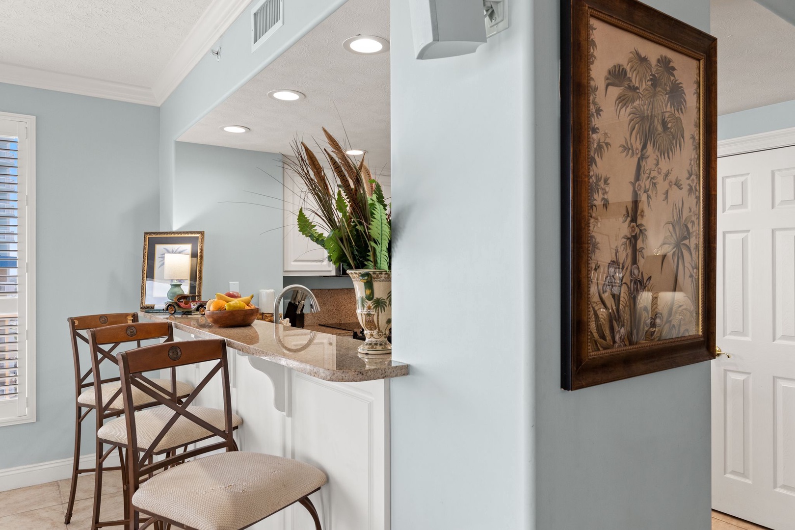 Enjoy your morning coffee at the open breakfast bar, surrounded by soft coastal colors and tropical touches that make this space feel like home.