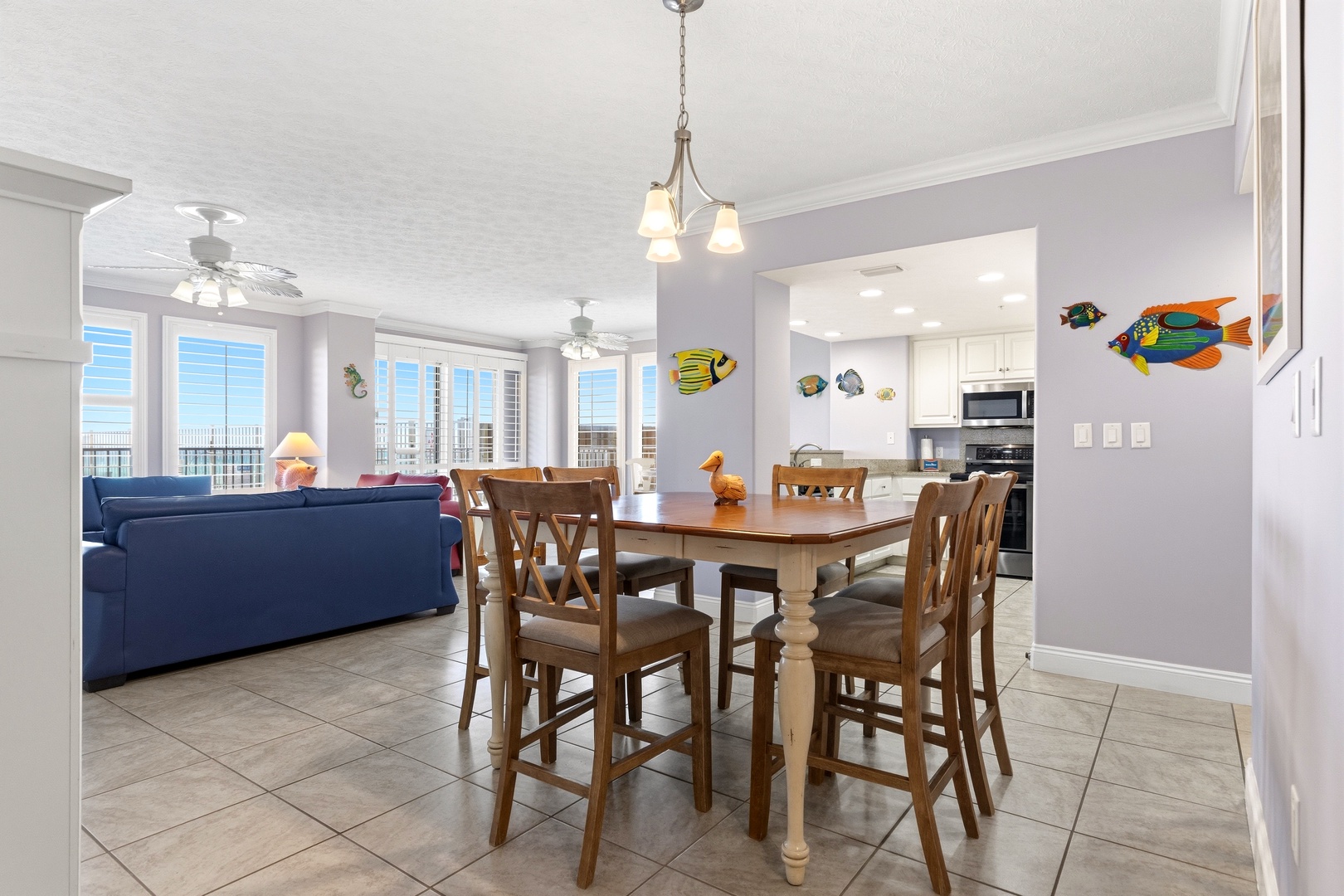 Your bright, open living space flows seamlessly from dining to kitchen, with cheerful tropical fish art welcoming you home after beach days.