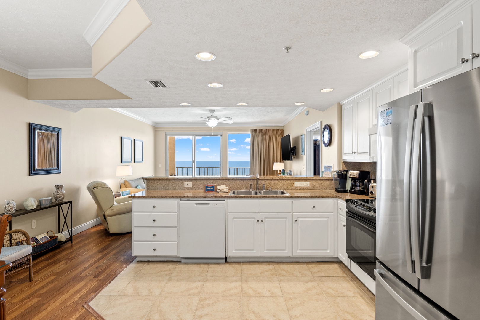 Your fully equipped kitchen flows into the living area, with stunning ocean views beyond—perfect for enjoying morning coffee or preparing meals while taking in the scenery.