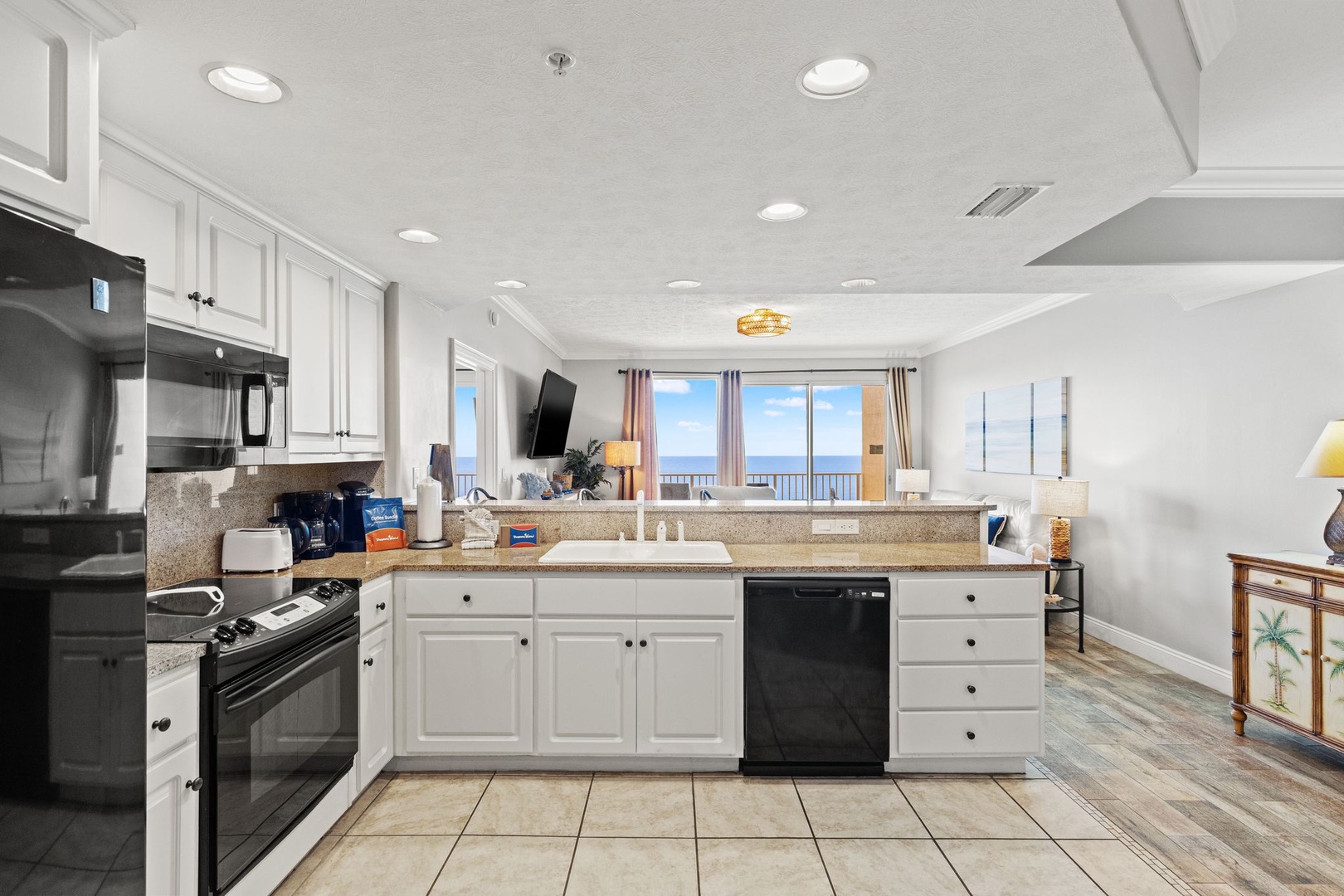 Bright, open kitchen flows into the living space, where windows frame stunning ocean views—your perfect backdrop for morning coffee and evening relaxation.