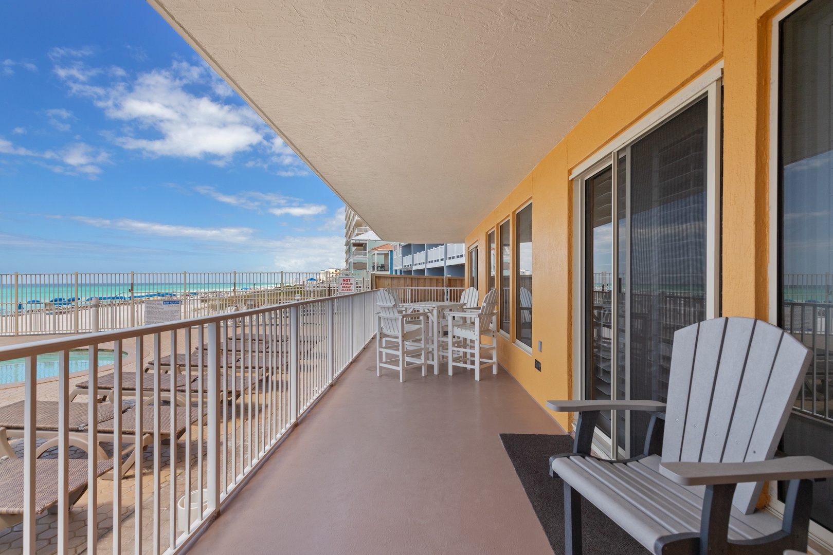 Relax on your private beachfront balcony with comfortable seating and dining space overlooking stunning turquoise waters and sandy shores.
