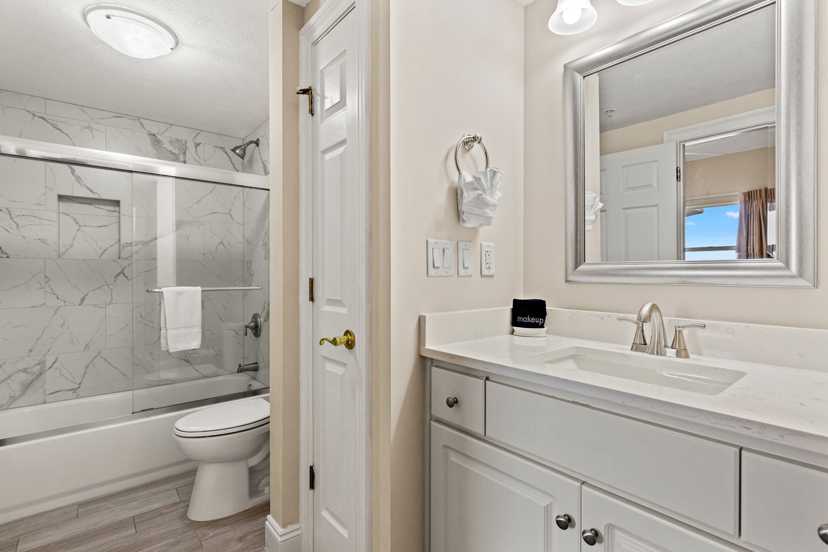 Refresh in your pristine bathroom featuring a marble-tiled shower and elegant vanity with all the comforts you need.