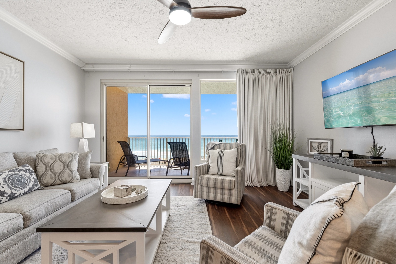 Unwind in your elegant living room where soft furnishings meet stunning ocean views through floor-to-ceiling windows.