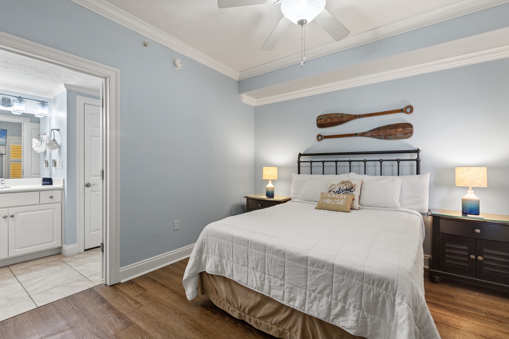 Your serene coastal bedroom features charming wooden oar decor and soothing blue tones that'll make you feel right at home by the sea.