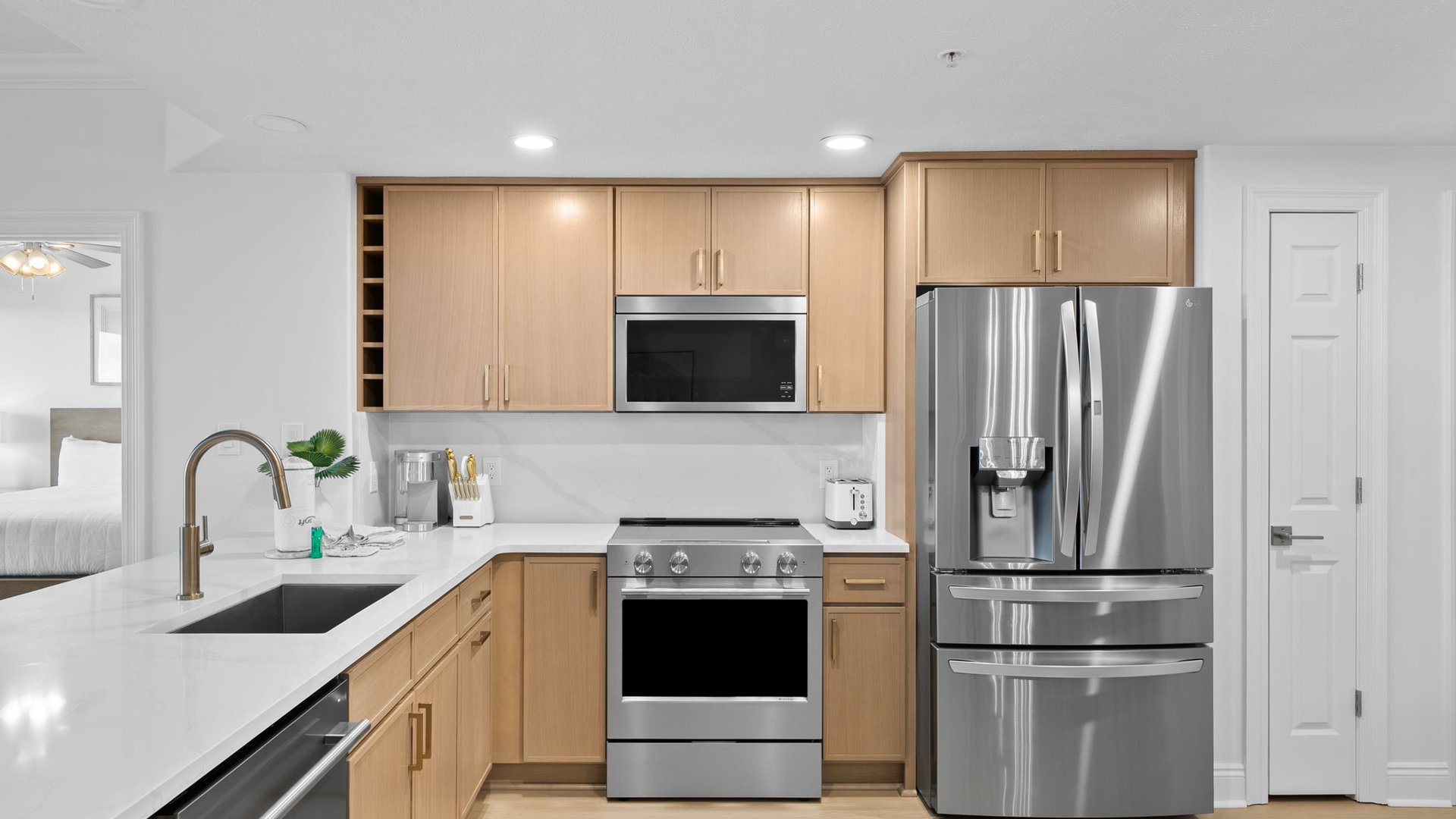 Your modern kitchen awaits with sleek stainless steel appliances, warm wood cabinets, and pristine white countertops perfect for preparing delicious meals.