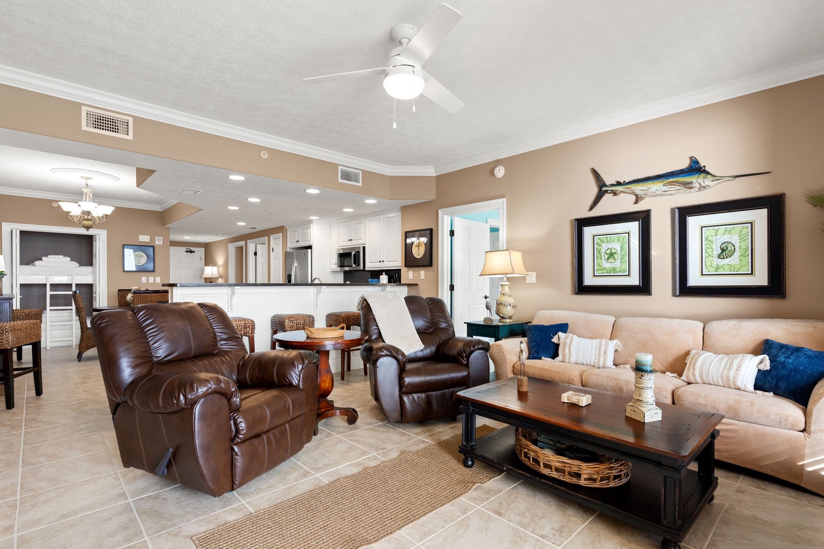 Unwind in your spacious open-concept retreat with coastal flair. Sink into plush recliners, gather around the coffee table, and enjoy the coastal-themed touches that make this living space feel like home.