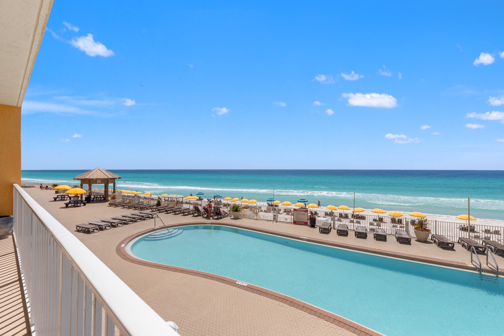 Stunning oceanfront view showcases the pristine beach, crystal-clear pool, and endless turquoise waters stretching to the horizon.