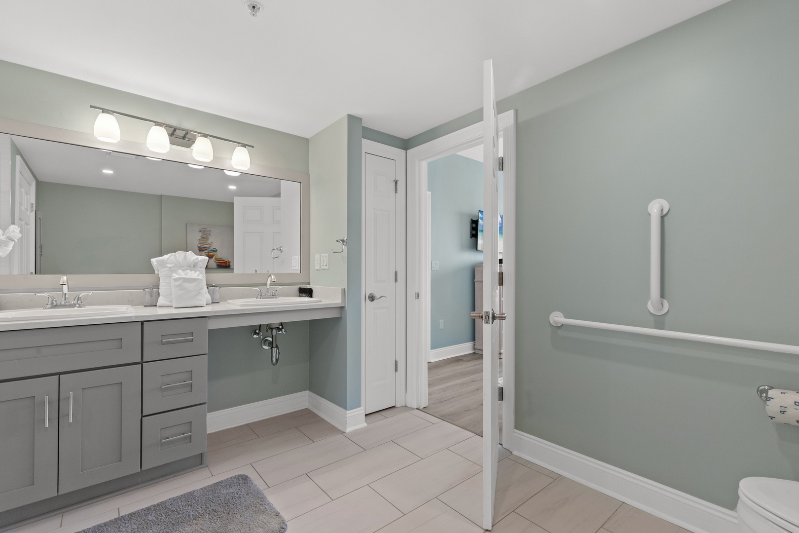 Refresh in your spacious accessible bathroom with dual vanities, perfect lighting, and thoughtfully placed grab bars for safety.