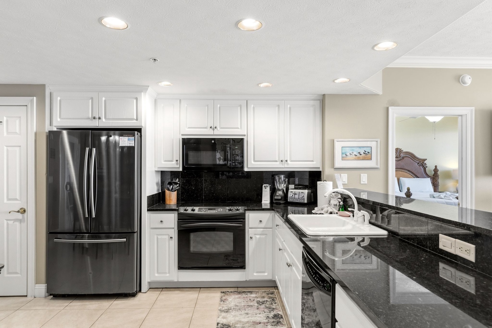 Your fully equipped kitchen features granite countertops, stainless steel appliances, and crisp white cabinetry—perfect for preparing meals during your stay.