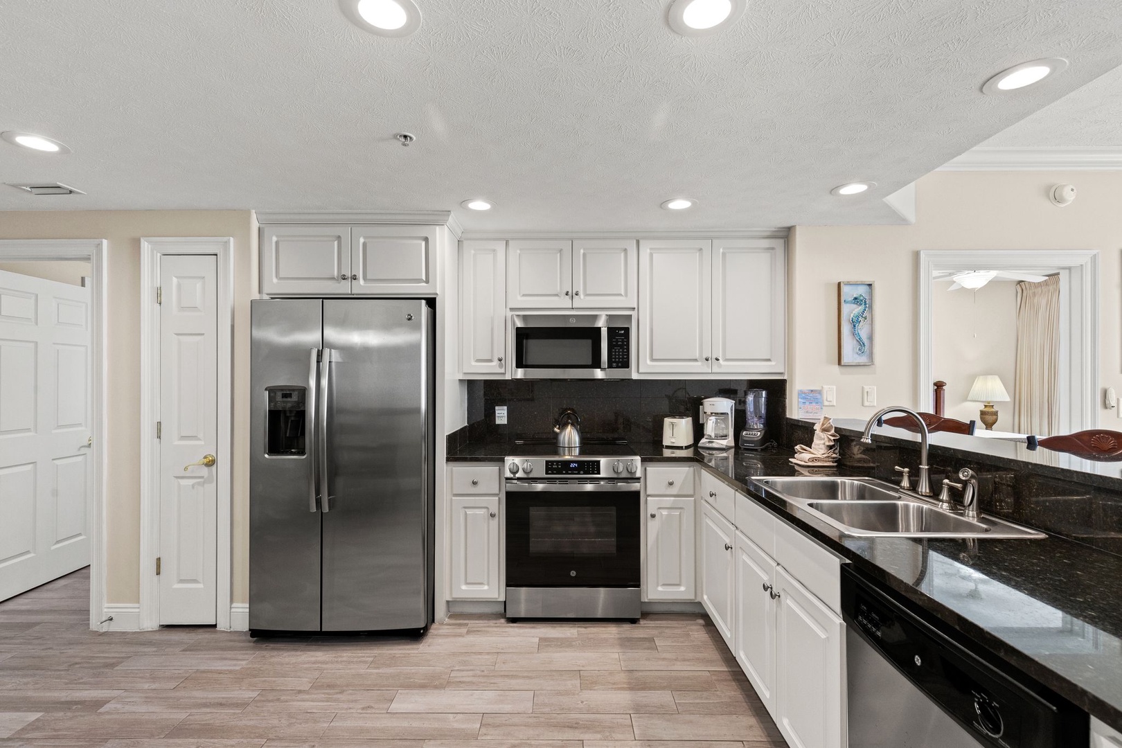 Your spacious kitchen features gleaming granite counters, stainless steel appliances, and crisp white cabinets—perfect for preparing memorable vacation meals together.
