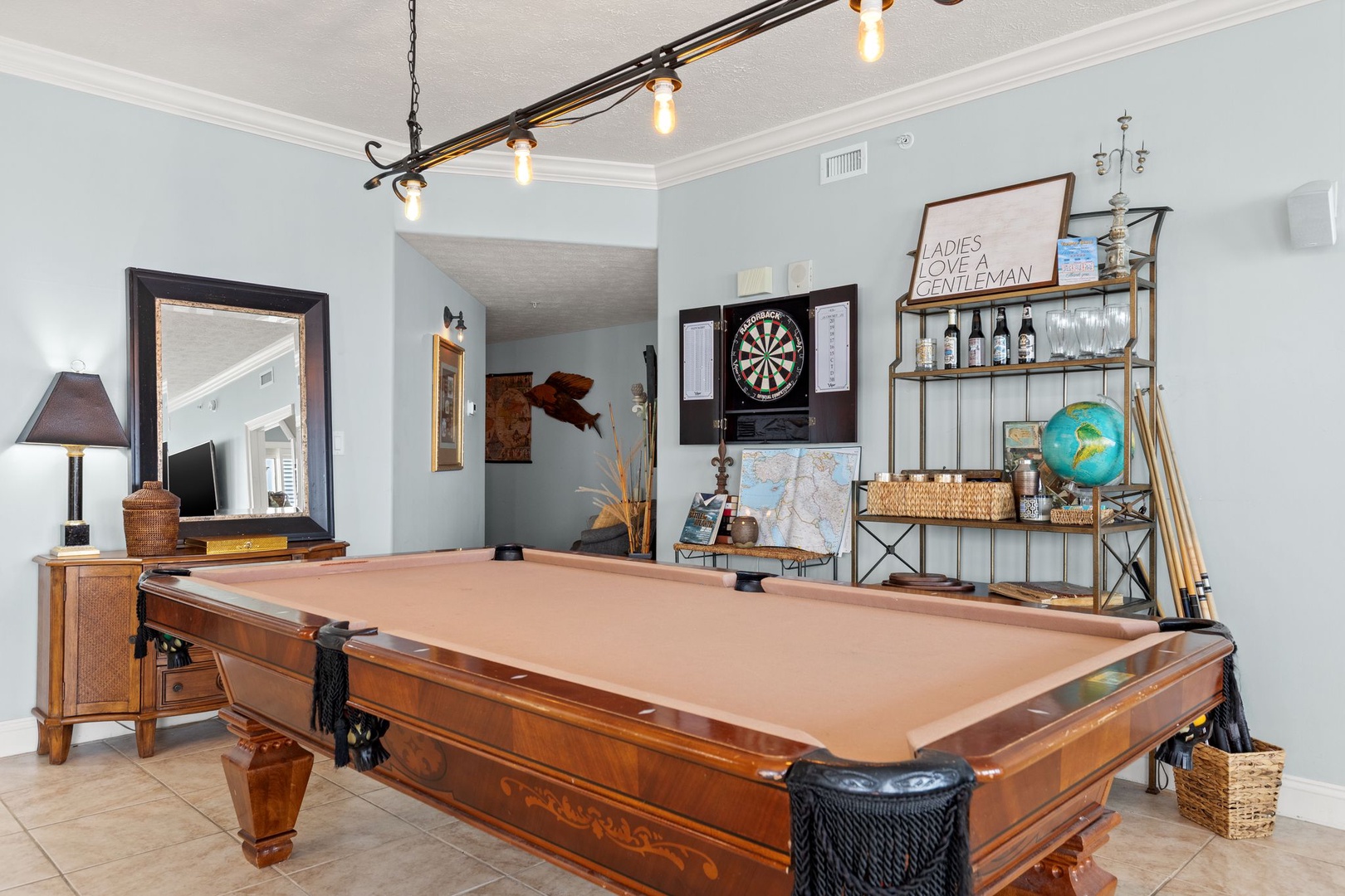 Challenge friends to pool or darts in this stylish game room, complete with a full-size billiard table, vintage bar cart, and ambient lighting for unforgettable evenings in.