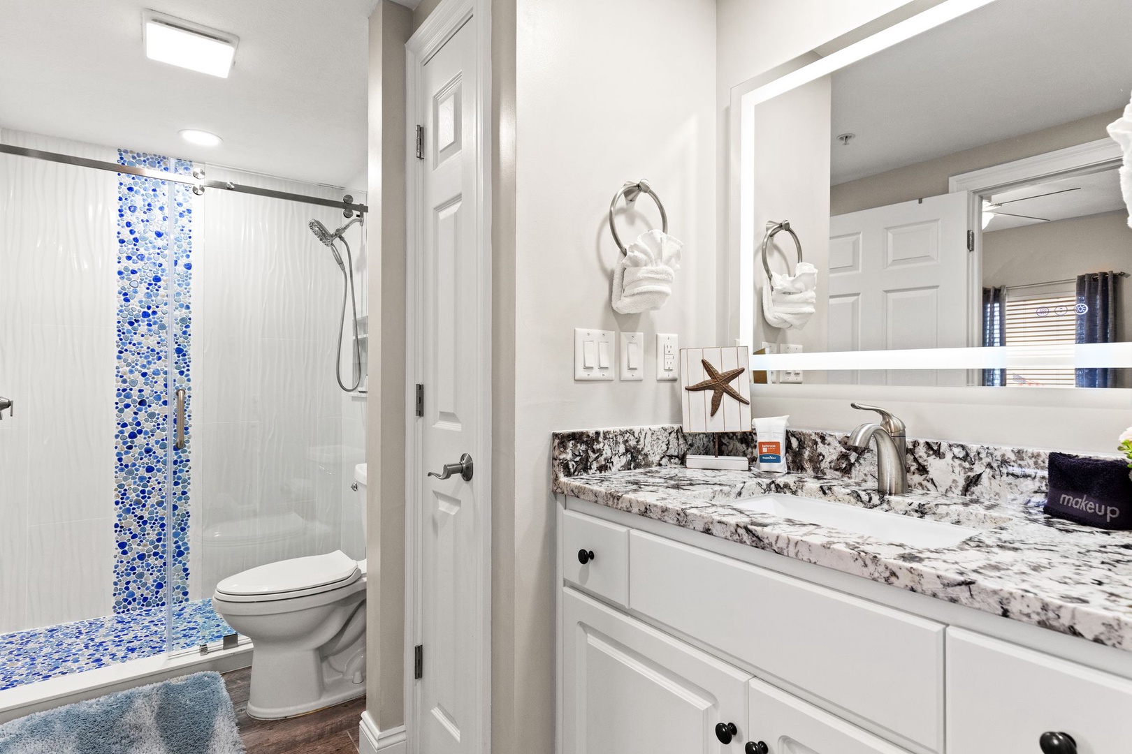 Step into your pristine en-suite, where coastal-inspired tilework and polished granite create a spa-like retreat. Fresh towels and thoughtful touches await your arrival.