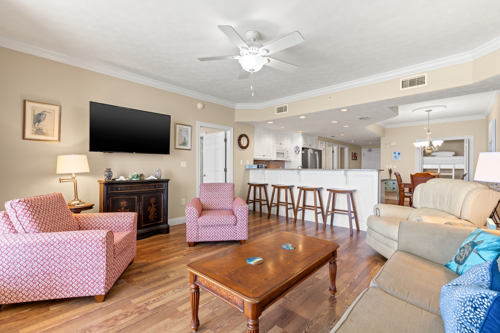 Picture yourself unwinding in this open, airy living space with comfortable seating and warm wood floors. The cheerful kitchen just steps away invites morning coffee and easy meal prep during your stay.