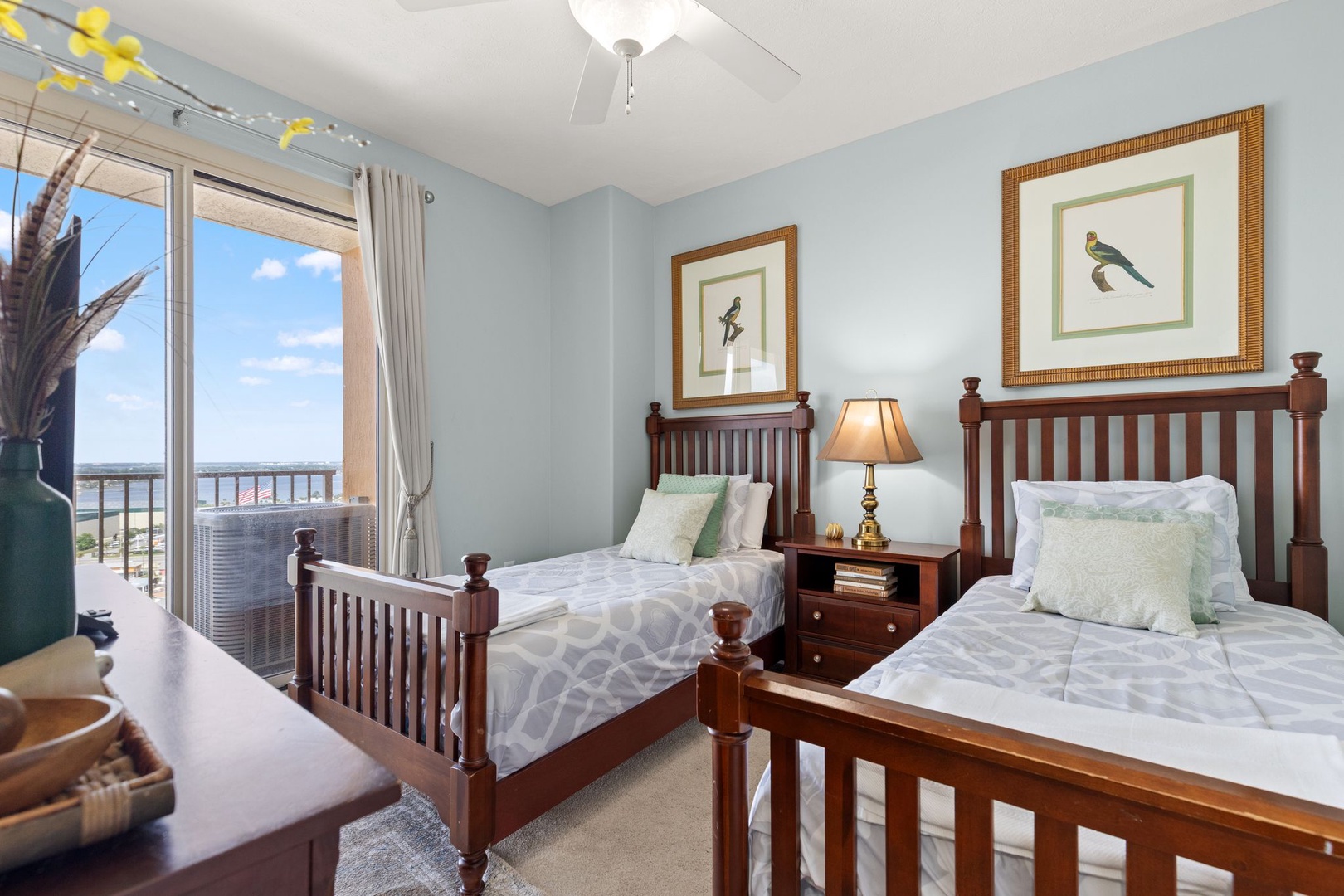 Twin beds with crisp linens invite restful sleep, while your private balcony opens to sweeping coastal views. Classic wood furnishings and soft coastal colors create a serene retreat after beach days.