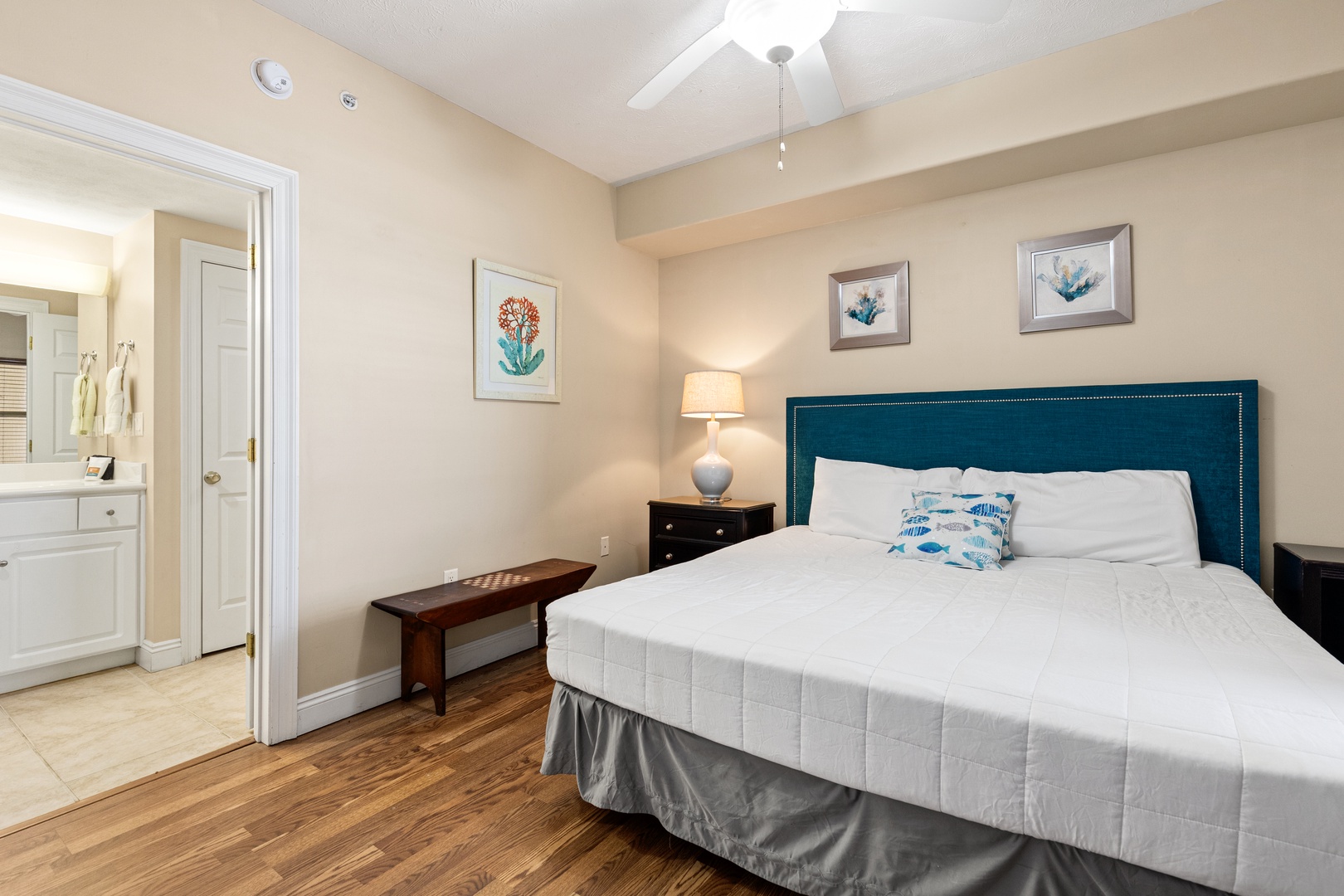 Your serene bedroom awaits with coastal-inspired art, a plush bed, and soft lighting—perfect for unwinding after your day's adventures.