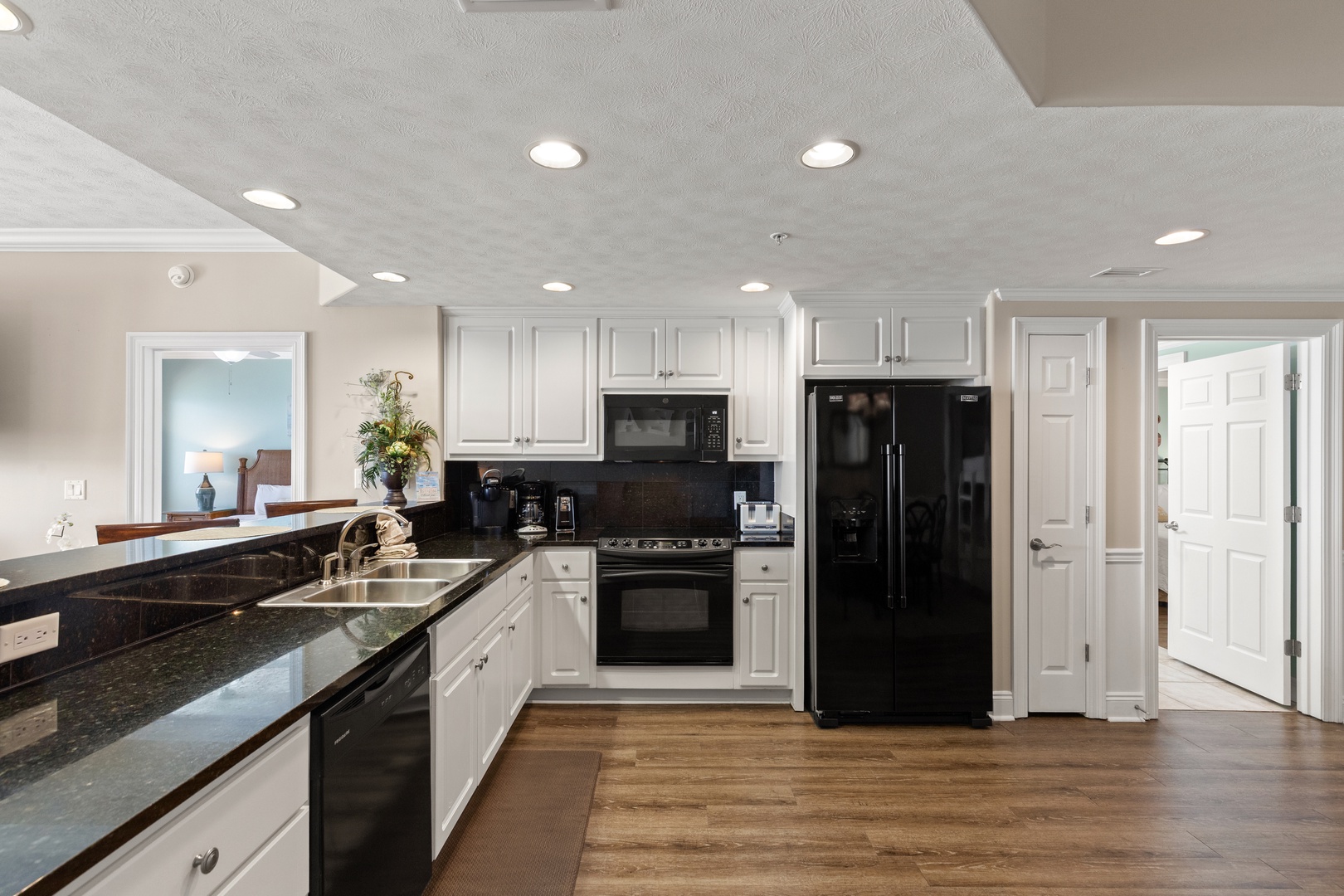 Your spacious kitchen features granite countertops, white cabinets, and modern black appliances—perfect for preparing memorable meals.