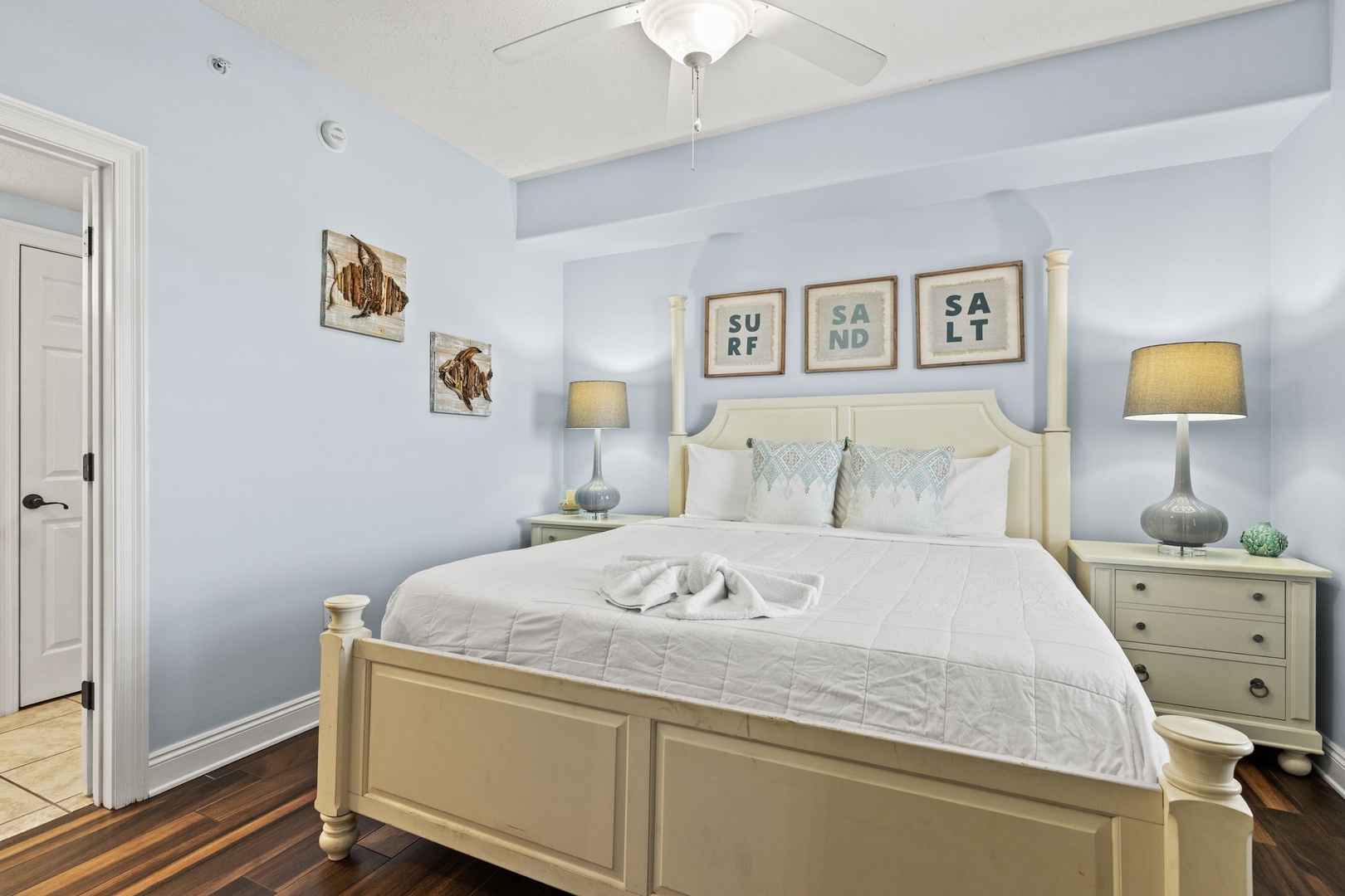 Rest easy in your serene coastal bedroom, where soft blue walls, beach-inspired art, and crisp linens invite peaceful sleep after sun-soaked days exploring nearby shores.