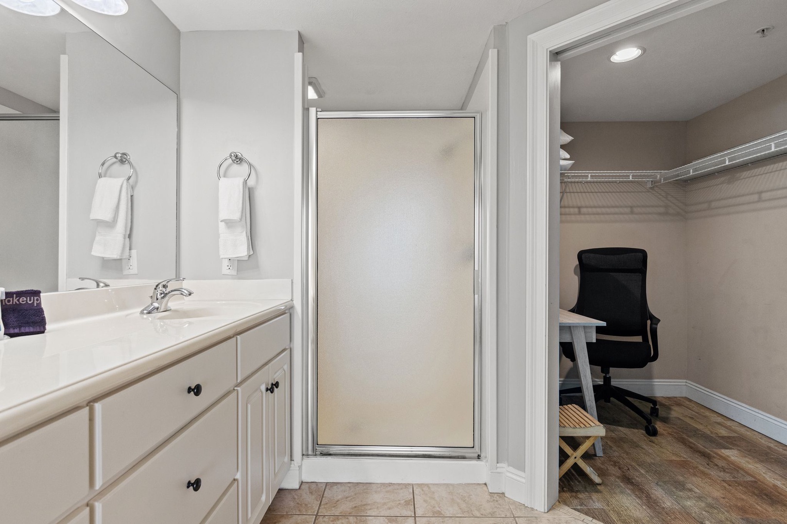 Freshen up in your private bathroom with a spacious walk-in shower, dual vanity, and plenty of storage. The adjoining dressing area offers closet space and a comfortable spot to get ready.