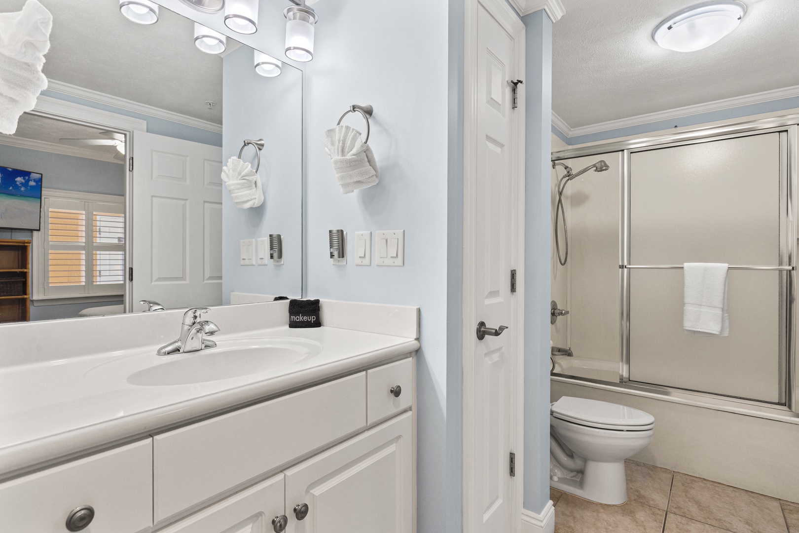 Refresh in your sparkling clean bathroom featuring modern vanity, bright lighting, and spacious walk-in shower with fresh towels awaiting your arrival.