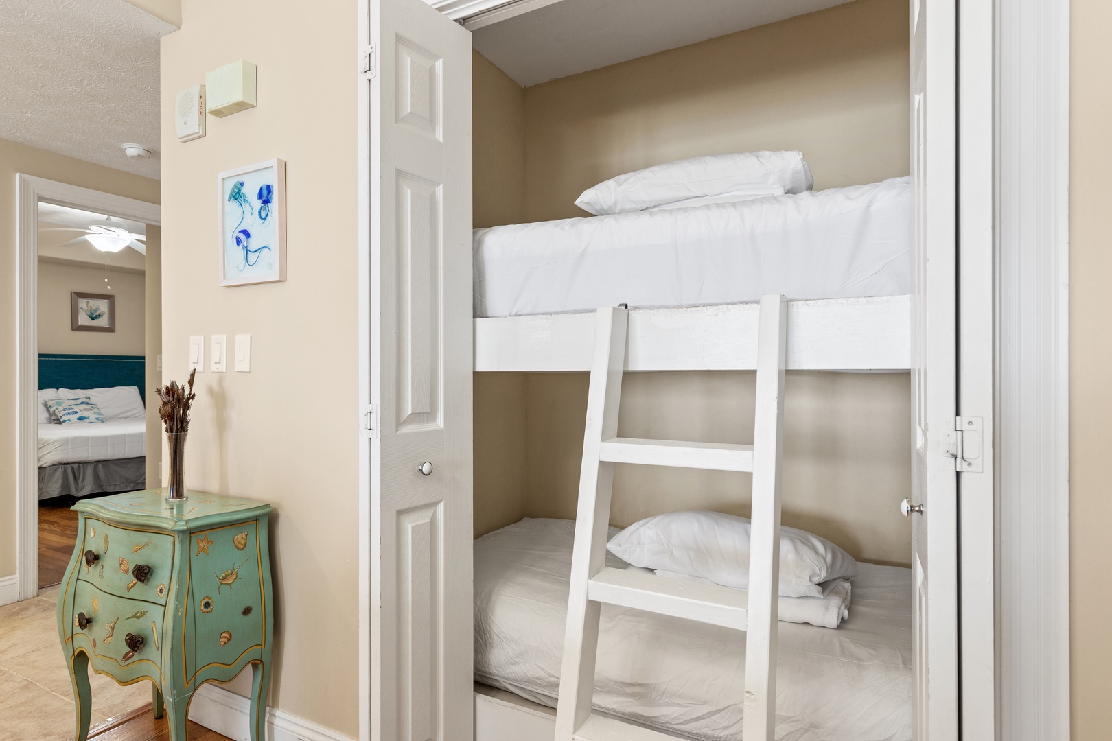 Cozy built-in bunk bed nook perfect for your kids or extra guests. Fresh linens and a smart sleeping space maximize comfort in a charming alcove.