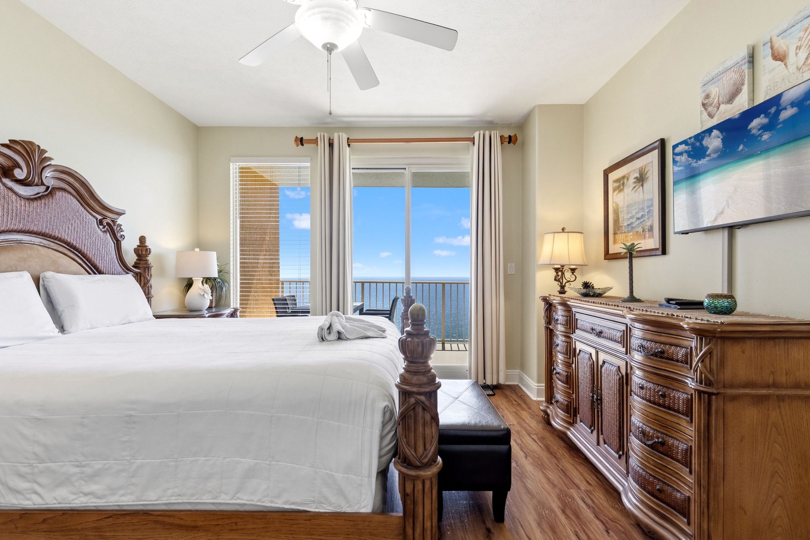 Wake up to stunning ocean views from your elegant bedroom, where rich wood furnishings and coastal artwork create the perfect seaside retreat.