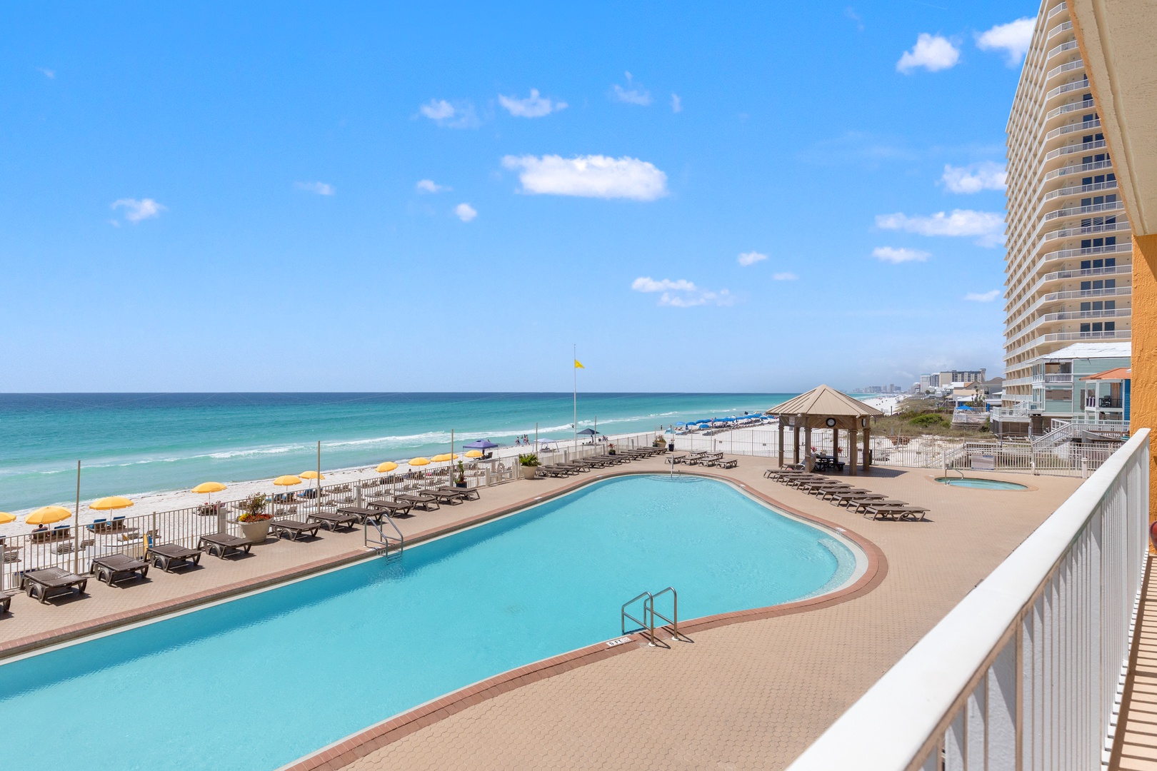 Spectacular oceanfront pool deck with pristine beach access and stunning Gulf waters stretching to the horizon.